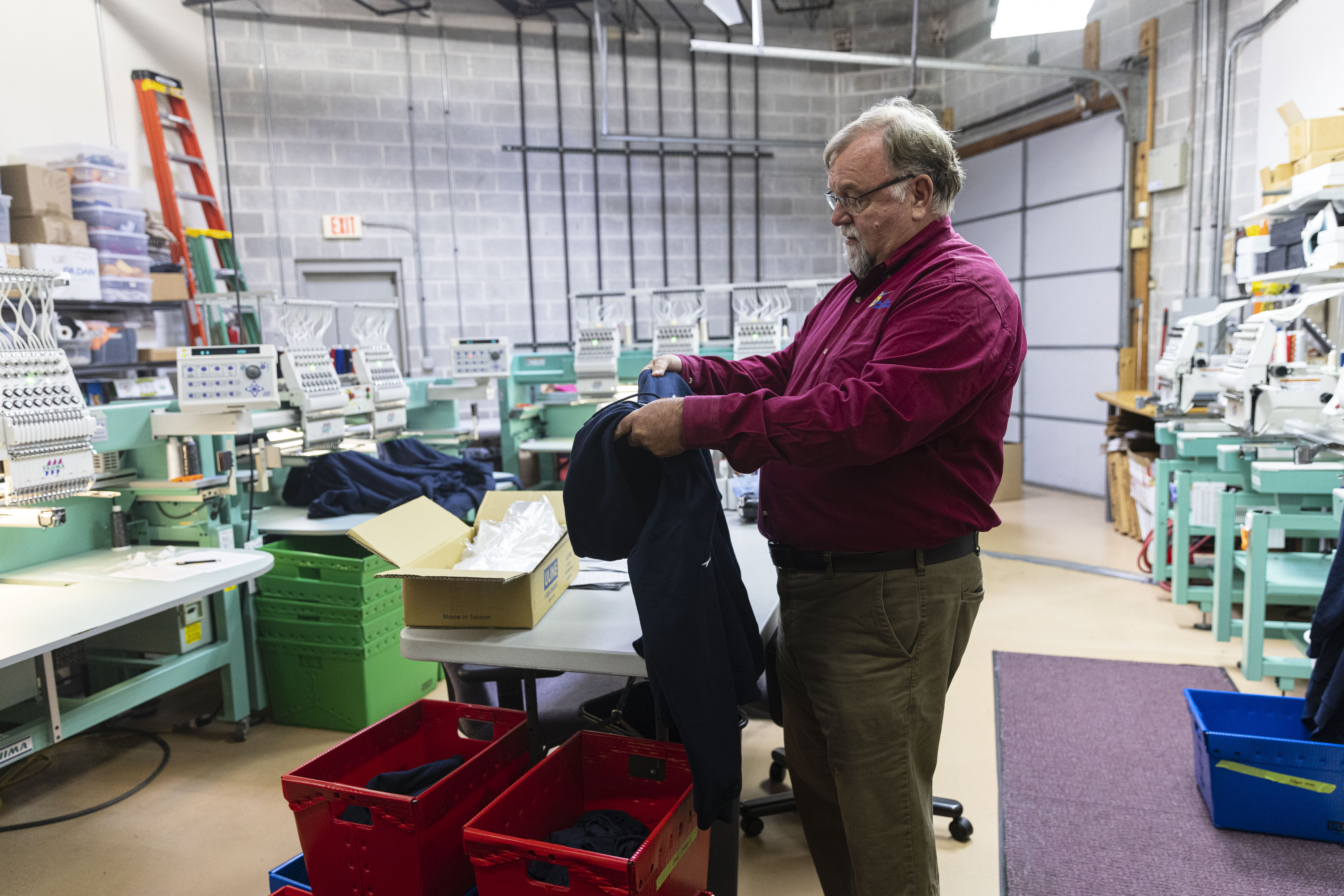 Gary Glenn, co-owner of StichMine Custom Embroidery checks the embroidery of a custom sweathshirt for any errors, Thursday, Oct. 28, 2021, at his shop his embroidery shop at 4344 Regency Drive in Glenview. 