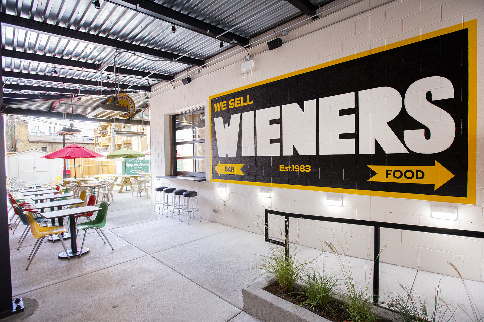 A large sign in brown and yellow reading “We sell wieners”