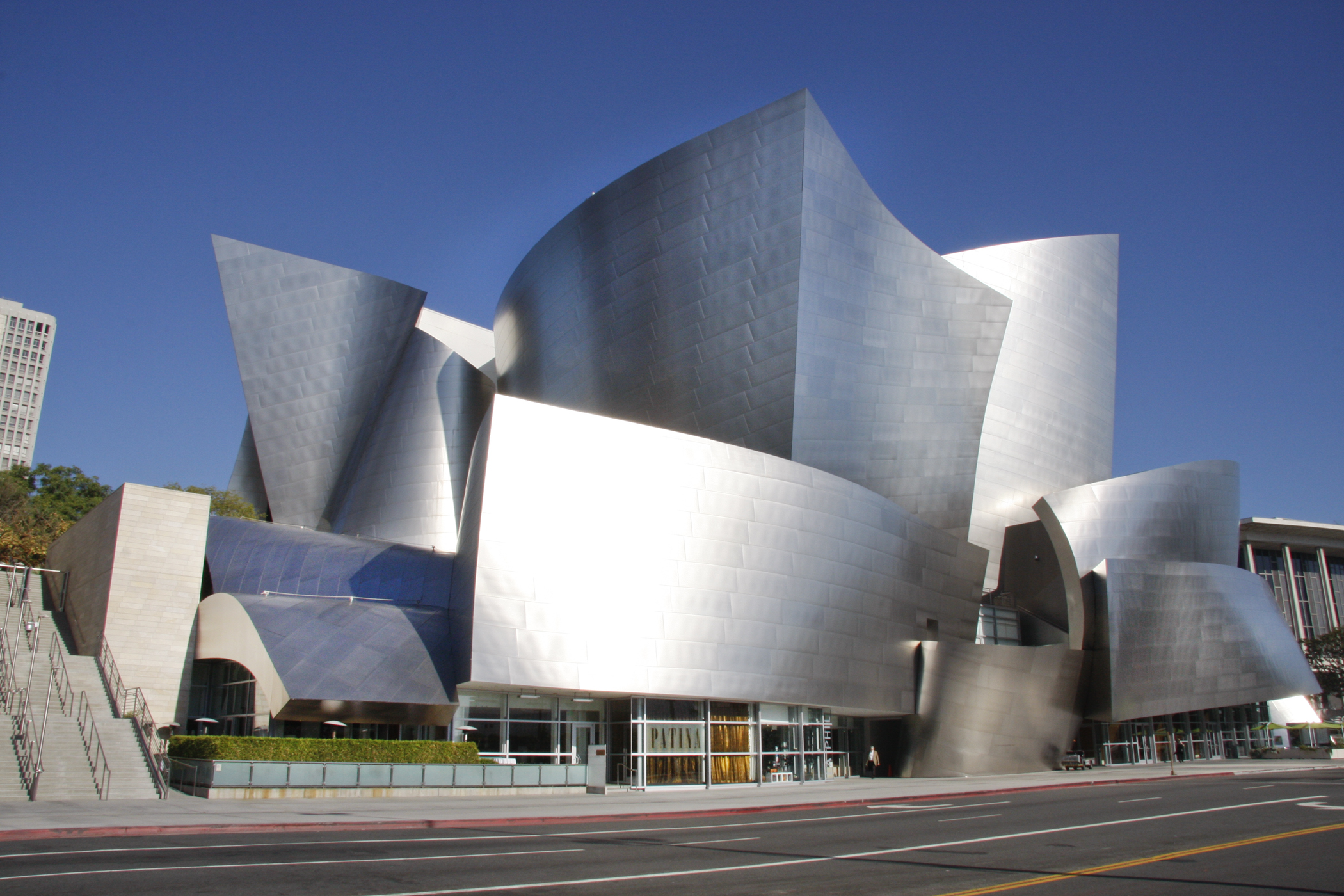 An exterior daytime shot of a gleaming wavy building with a music venue inside.