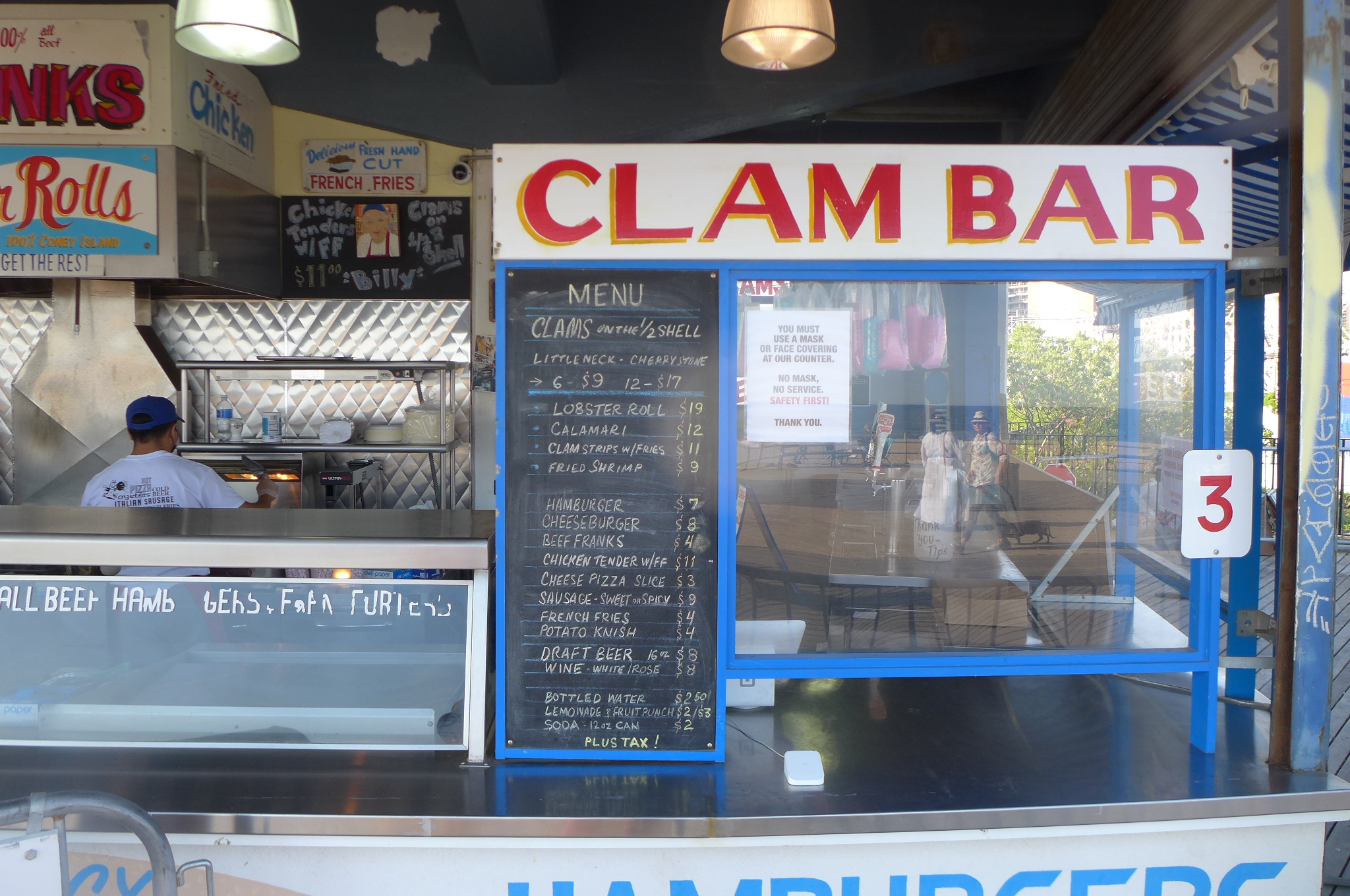 A counter with a chalkboard menu and sign that reads Clam Bar.