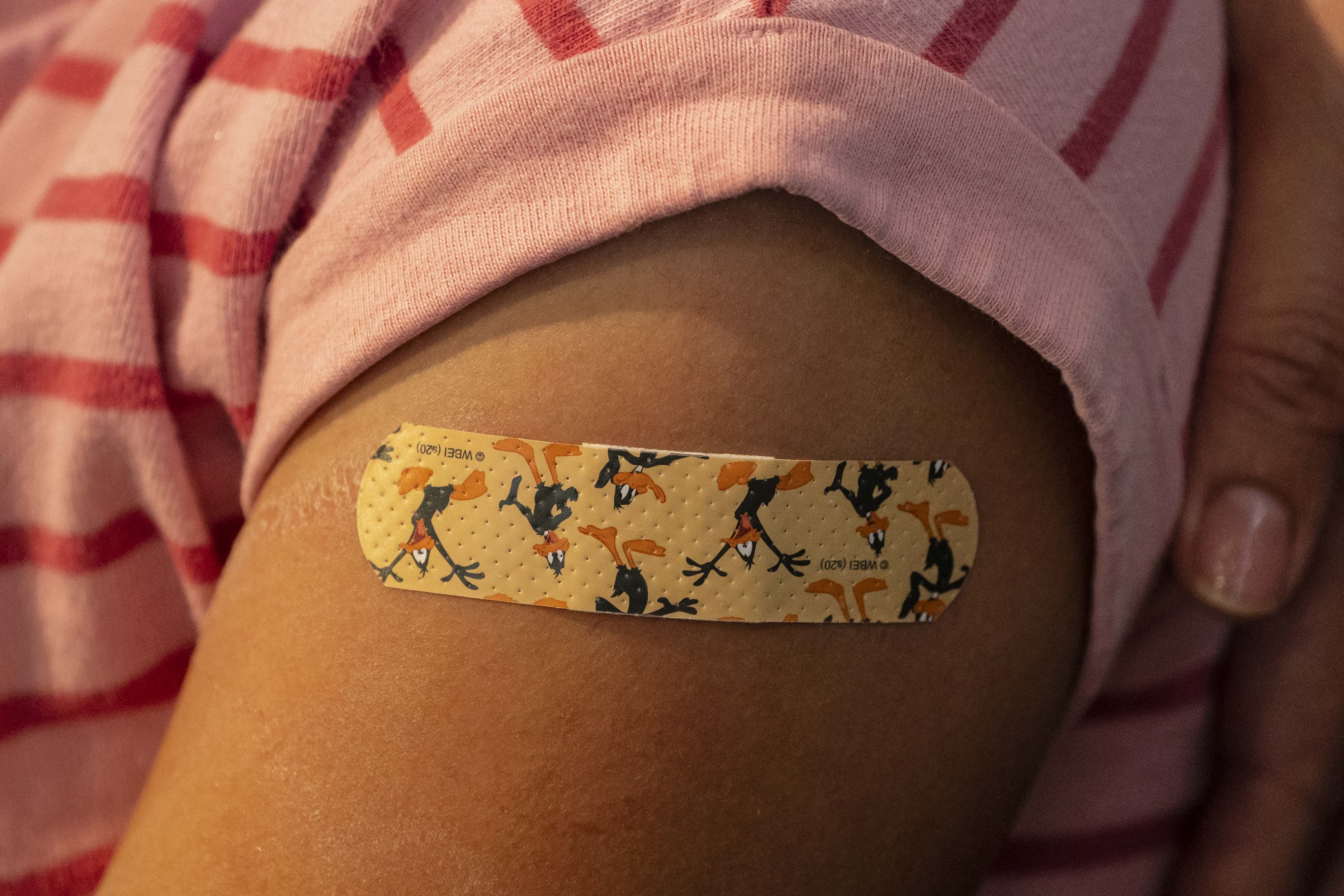 A bandaid adorns a child’s arm. New York City is extending its $100 COVID vaccine incentive program to children who get shots at their school next week.