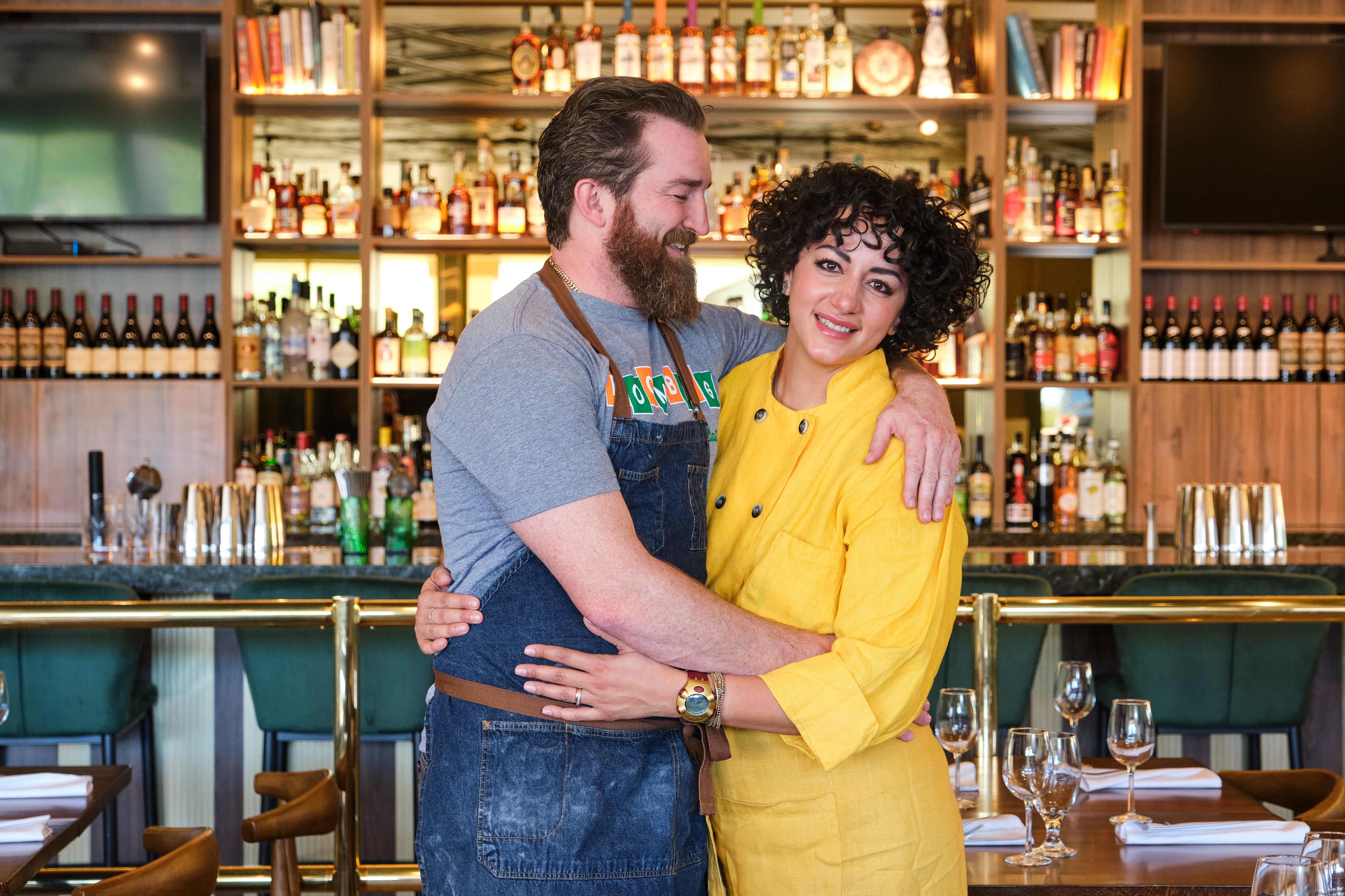 Christian Page and Ellia Aboumrad-Page embracing at their new restaurant.
