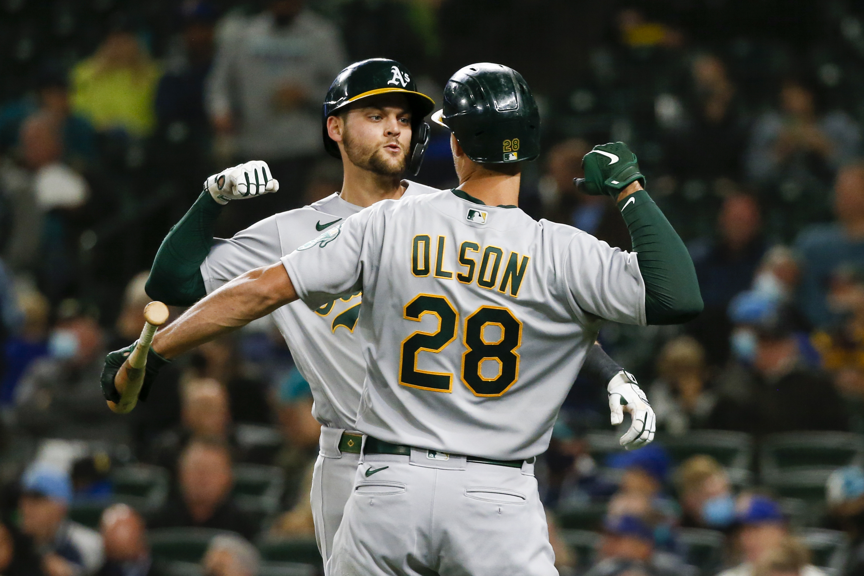 Oakland Athletics right fielder Chad Pinder (4) celebrates with Oakland Athletics first baseman Matt Olson (28) after hitting a solo-home run against the Seattle Mariners during the fourth inning at T-Mobile Park.