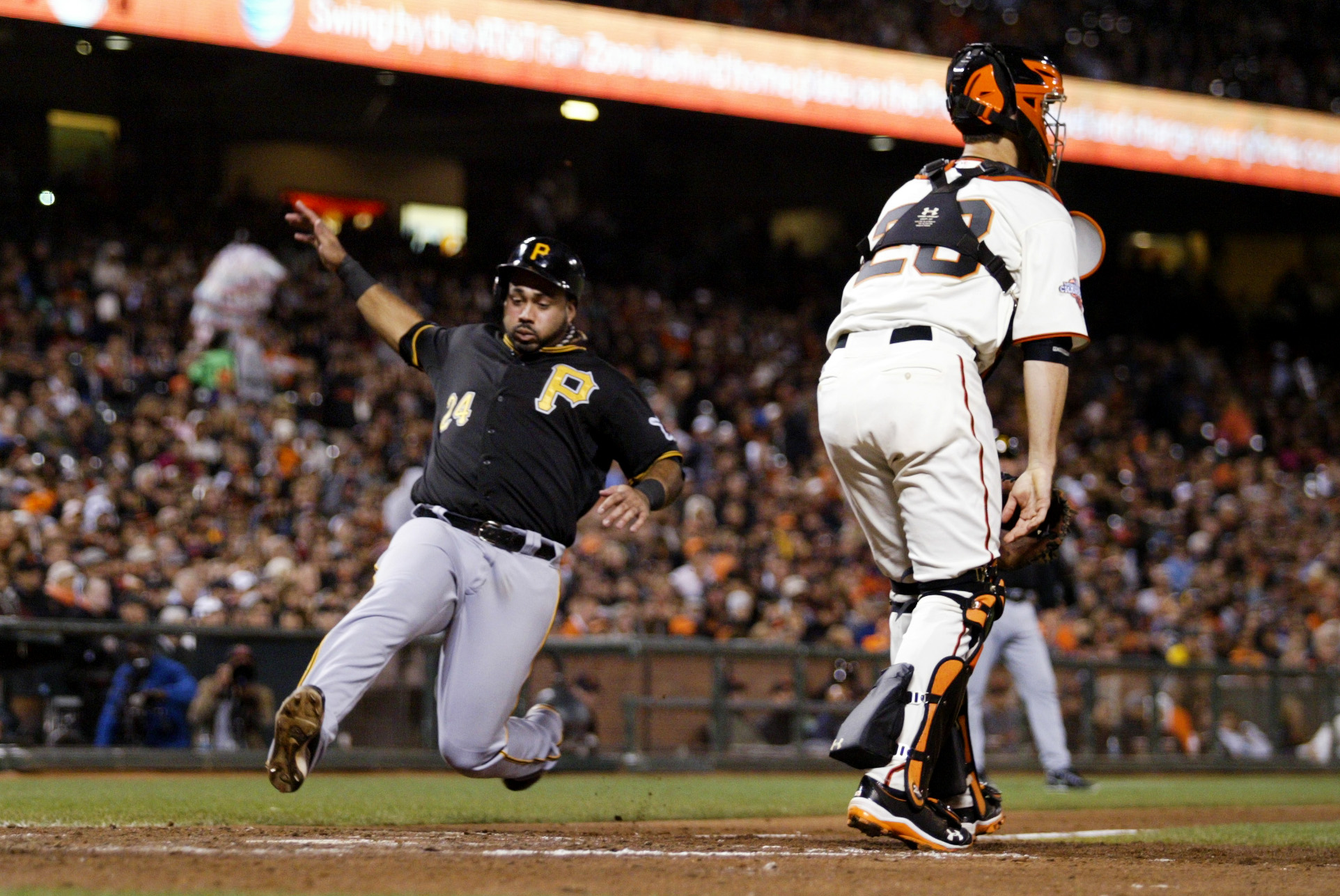 Pittsburgh Pirates’ Pedro Alvarez (24) scores on a sacrifice fly by Gaby Sanchez (14) as San Francisco Giants catcher Buster Posey (28) looks on in the fifth inning of a MLB game at AT&amp;T Park in San Francisco, Calif., on Thursday, Aug. 22, 2013. (Ray Chav