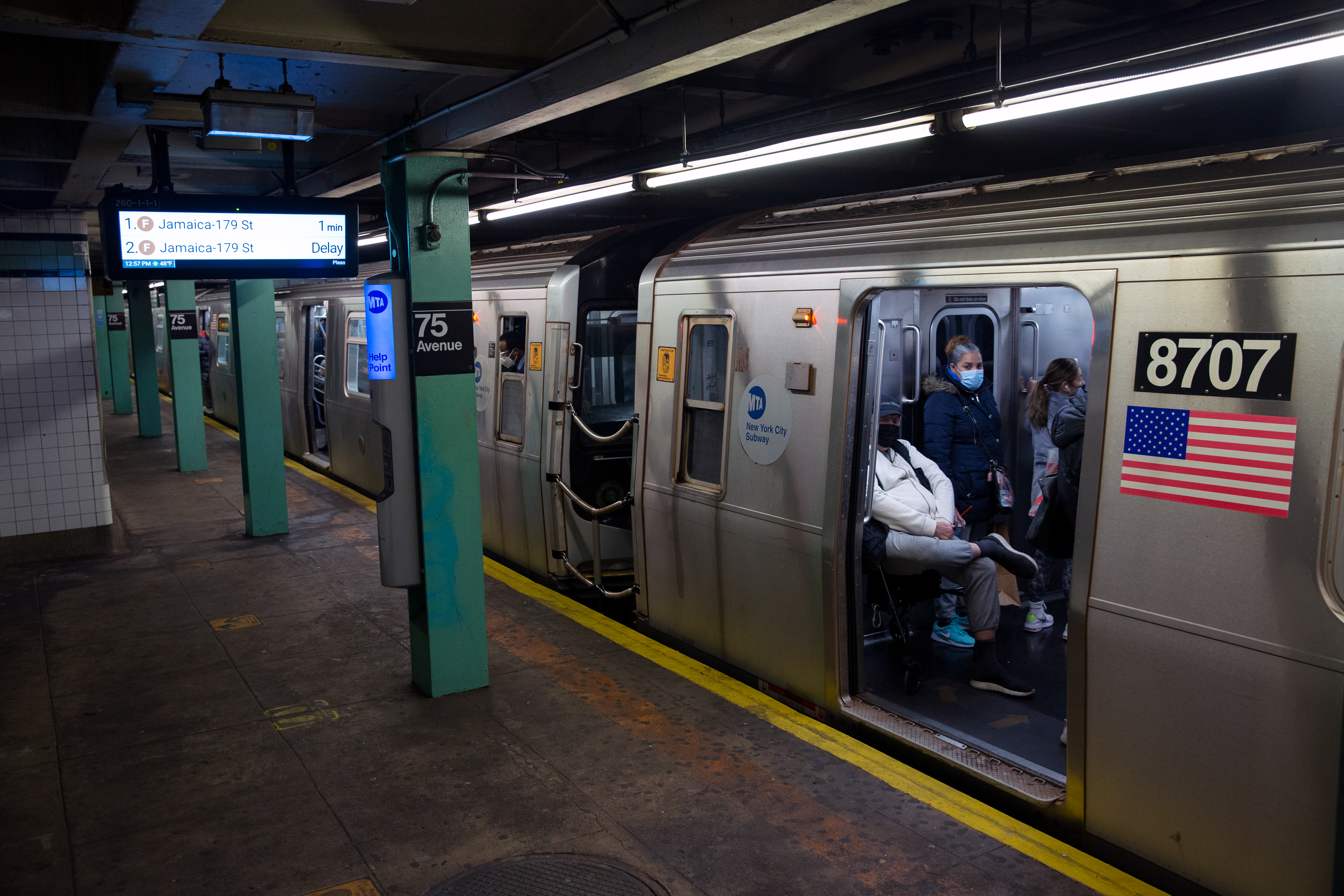 Riders wait for an E train to leave the 75th Avenue station under Queens Boulevard in Forest Hills, Nov. 16, 2021.