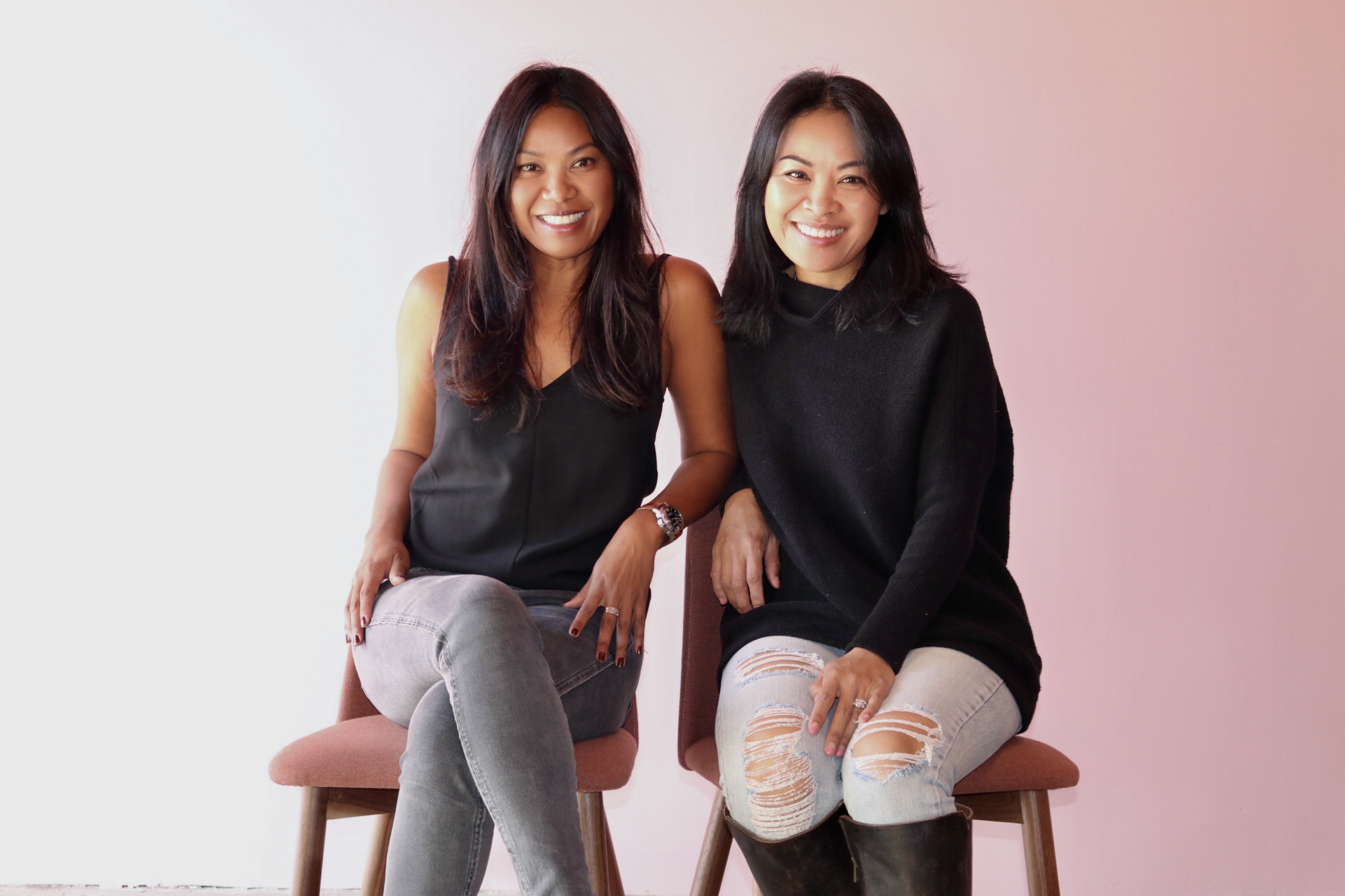 Katy Noochlaor and Chef Amanda Kuntee of Tuk Tuk Thai sitting on chairs with a pink background.