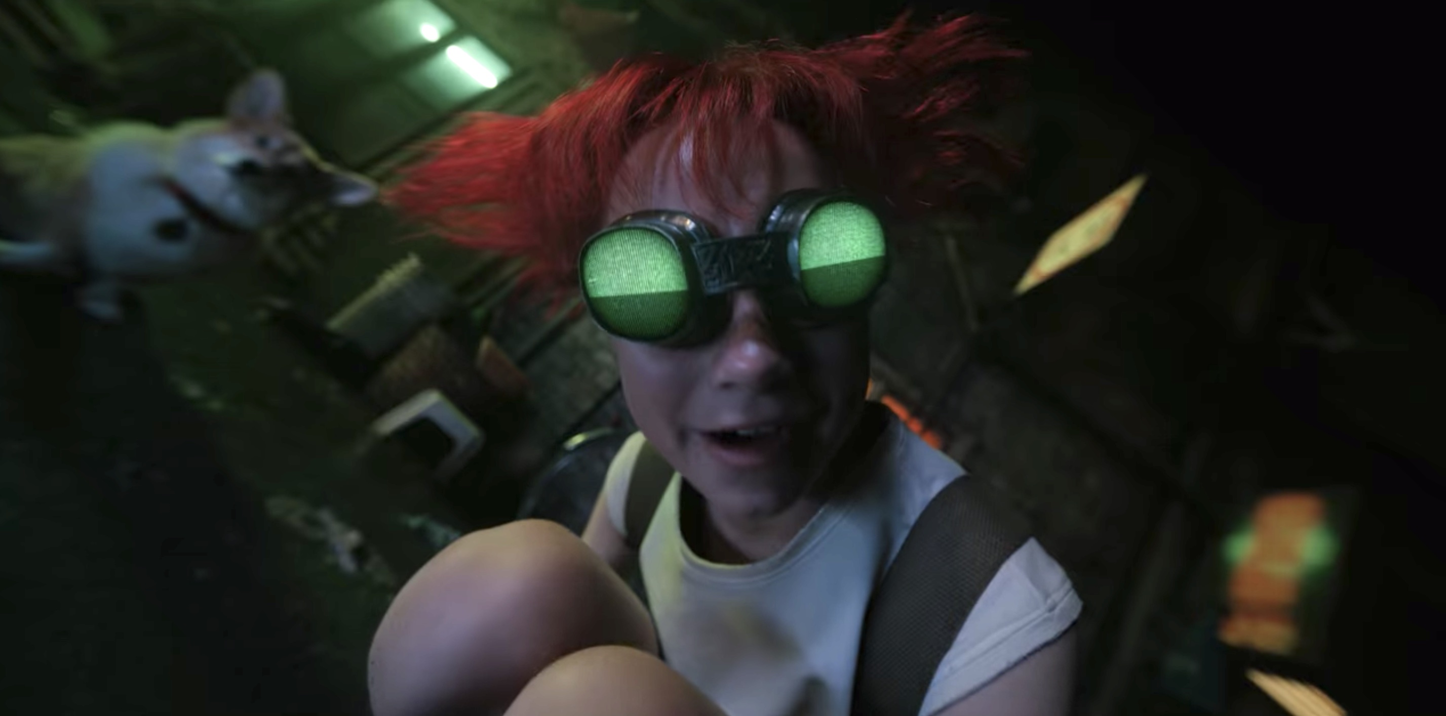 Ed (played by Eden Perkins) with red hair, green goggles, their white t-shirt, acting wild next to Ein the corgi doll in Cowboy Bebop