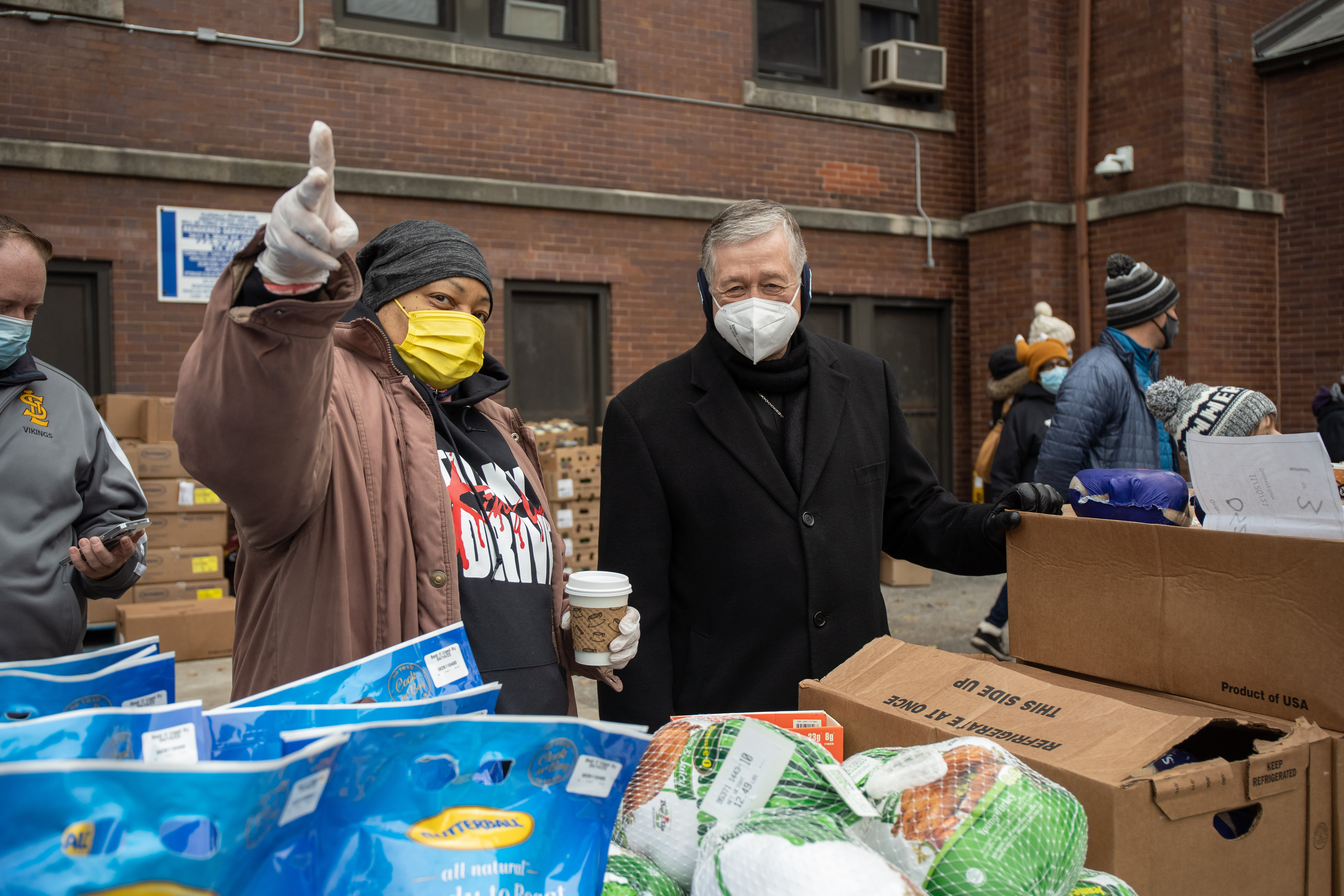 Cardinal Blase Cupich speaks to Zandra Harris, who has been volunteering with the church for 12 years, during a food and winter gear giveaway outside St. Moses the Black Parish Food Pantry in the Park Manor neighborhood.