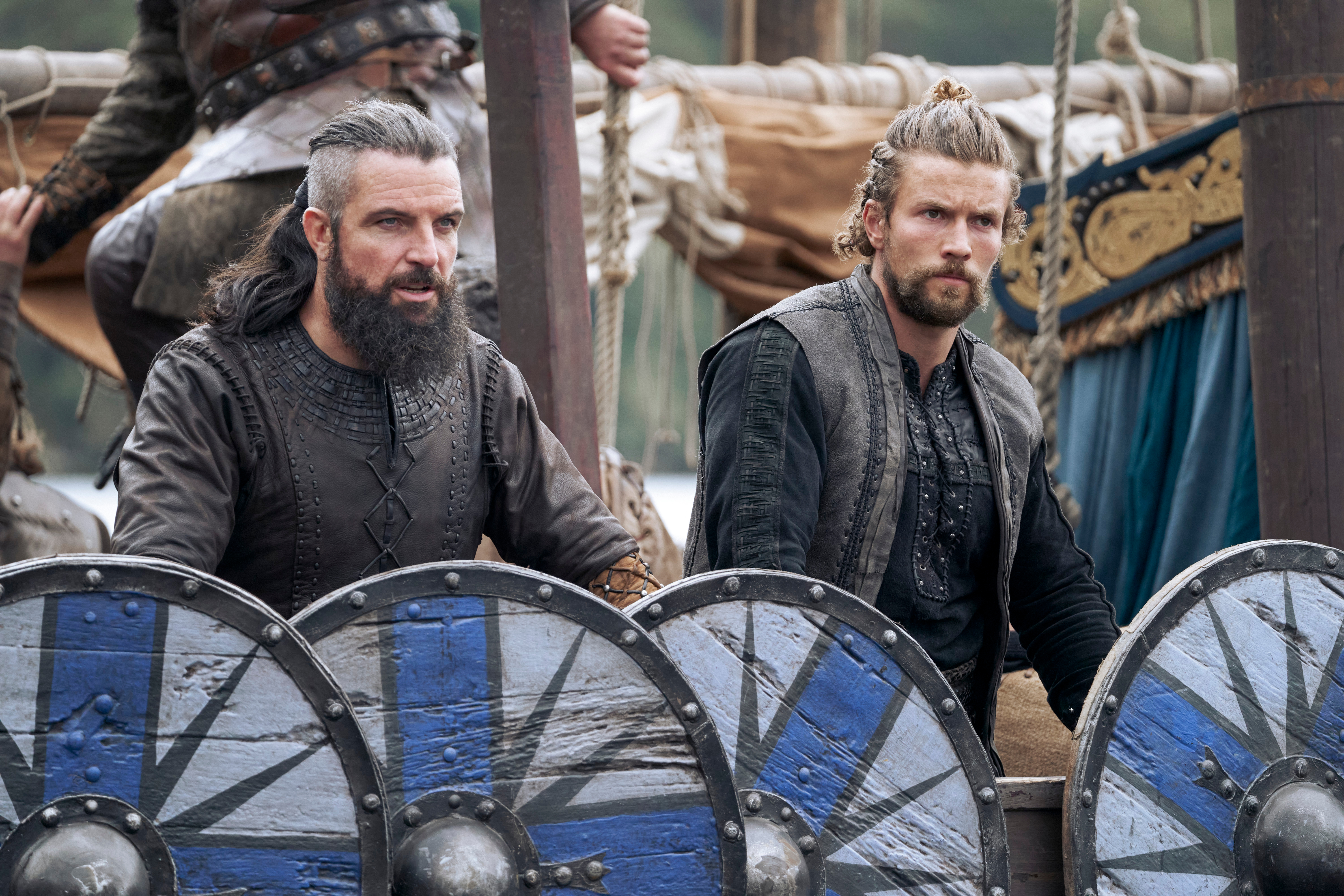 Canute and Harald stand behind their shields on a battlefield in Vikings: Valhalla