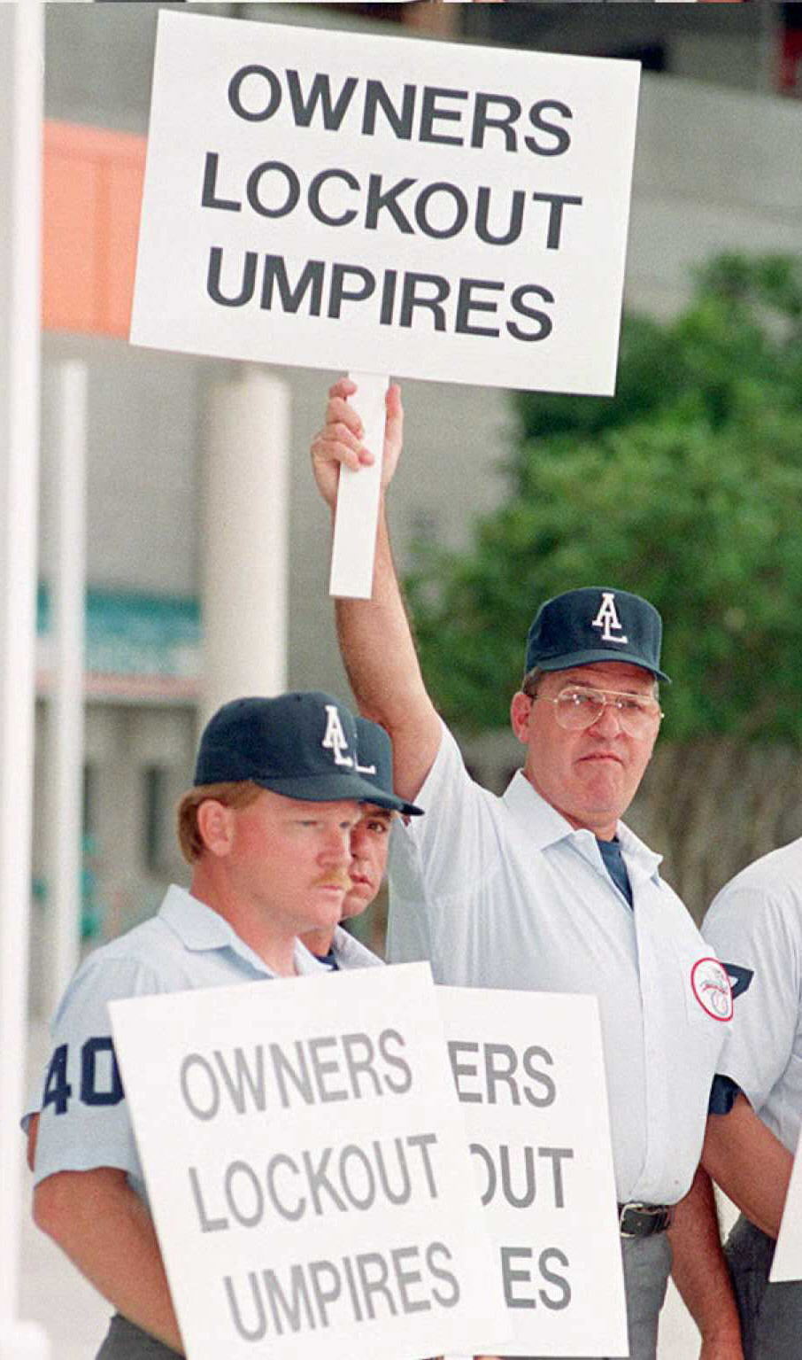Umpire Vic Voltagio holds up a sign reading “Owner