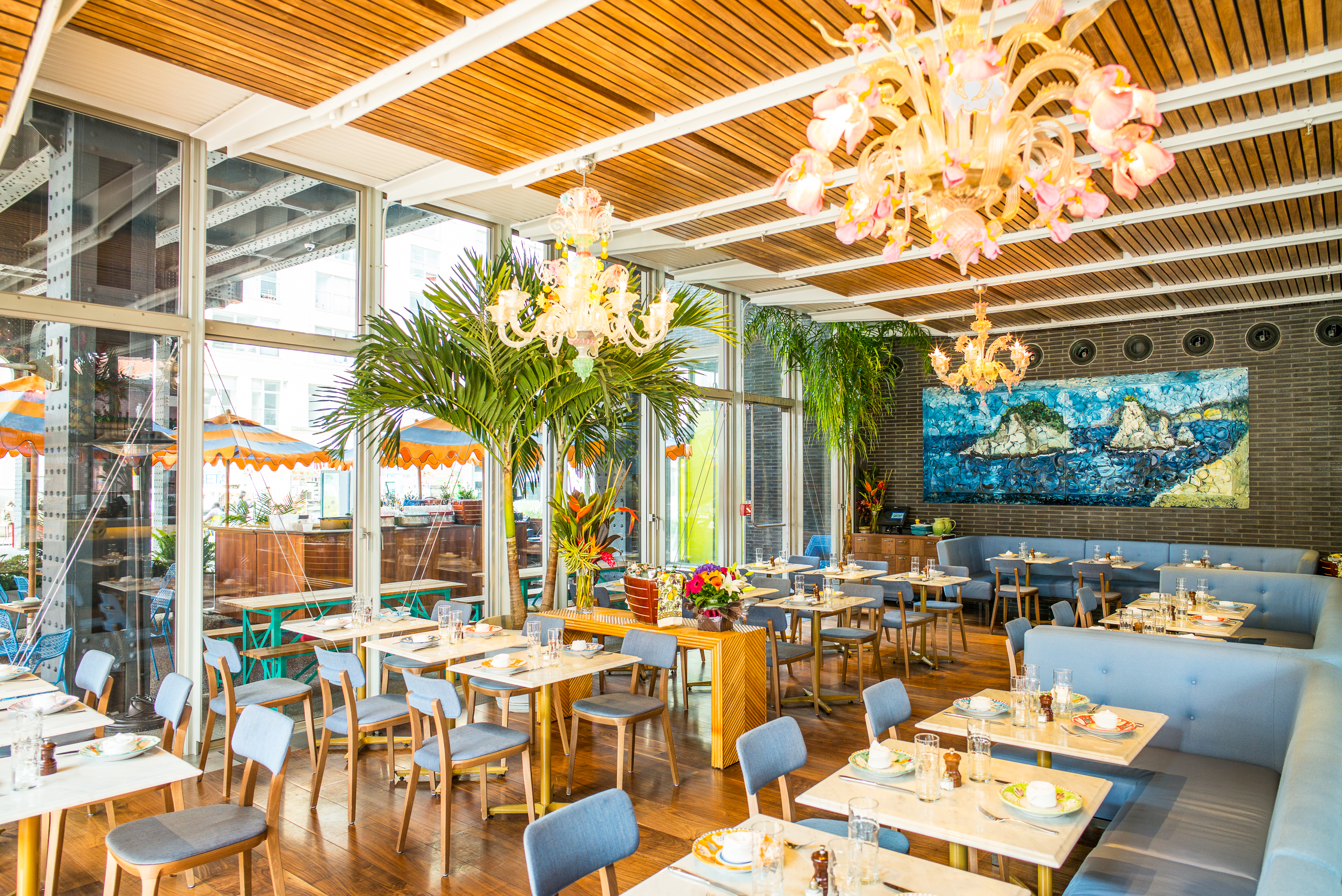 Santina’s dining room has a chandelier up top and floor-to-ceiling windows in the back.