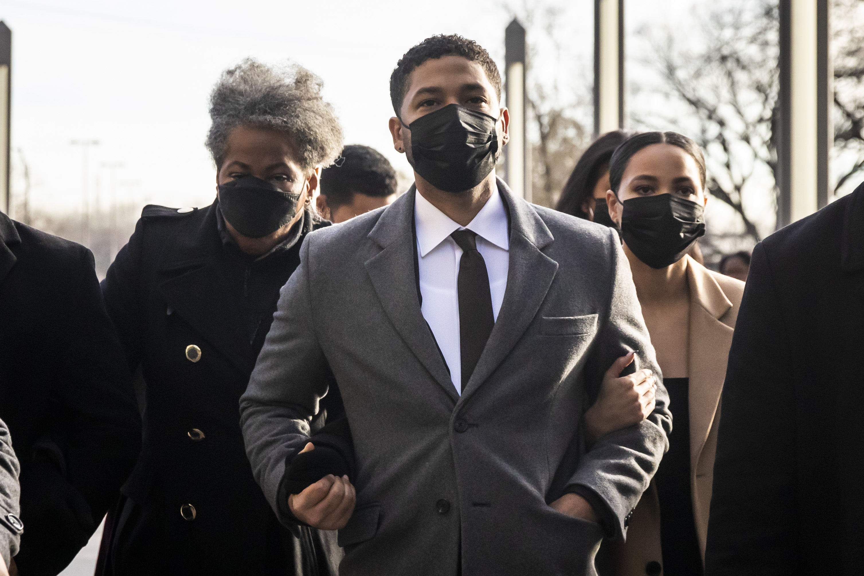 With his mother, Janet Smollett, on his right arm and sister, Jurnee Smollett, on his left arm, former “Empire” star Jussie Smollett walks behind bodyguards into the Leighton Criminal Courthouse, Thursday morning.
