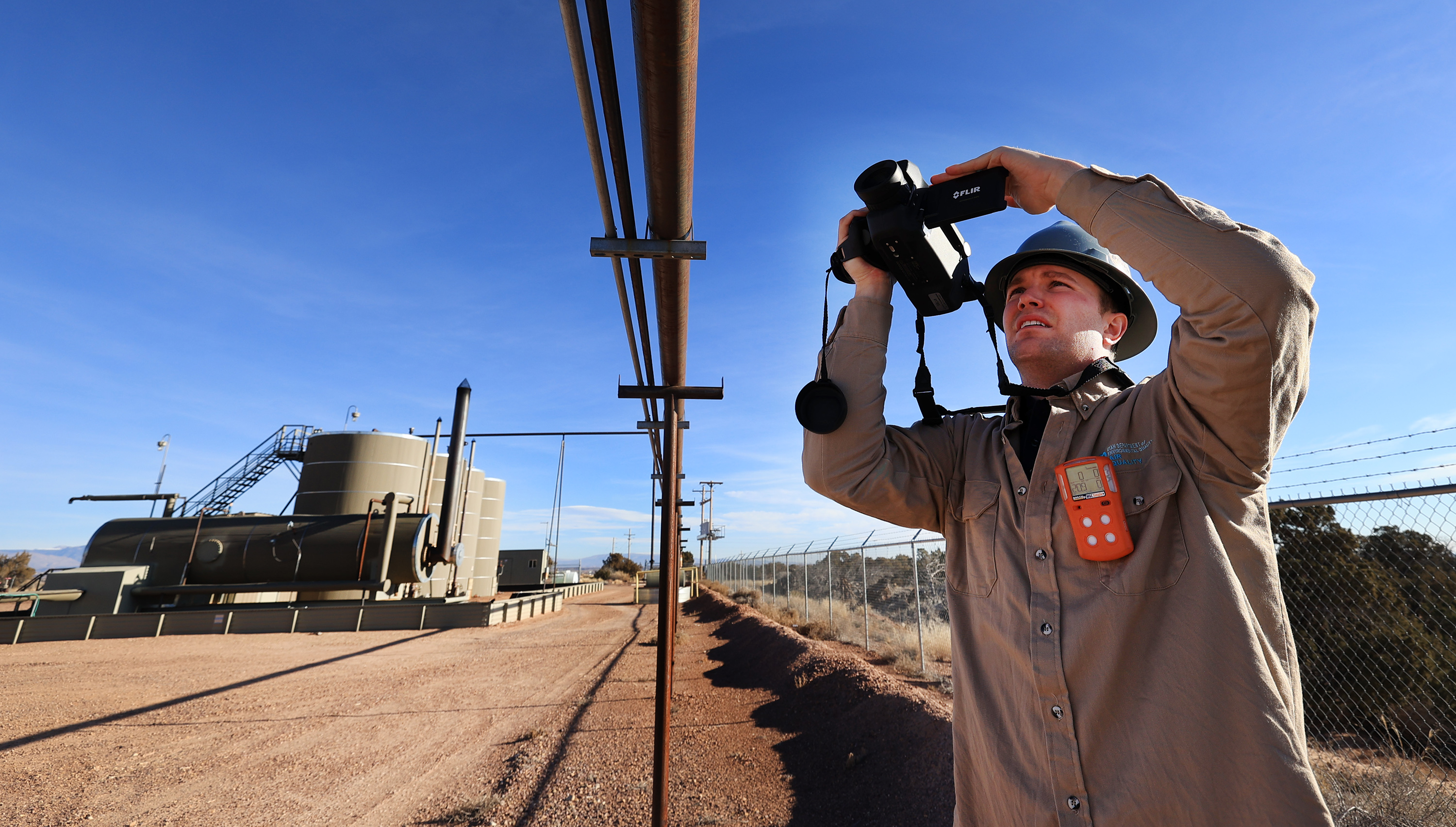 Stephen Foulger, an environmental scientist with the Utah Department of Environmental Quality, uses a Flir gas detection camera to look at welded joints on a pipeline during an inspection of an oil pump site near Roosevelt on Wednesday, Dec. 1, 2021.