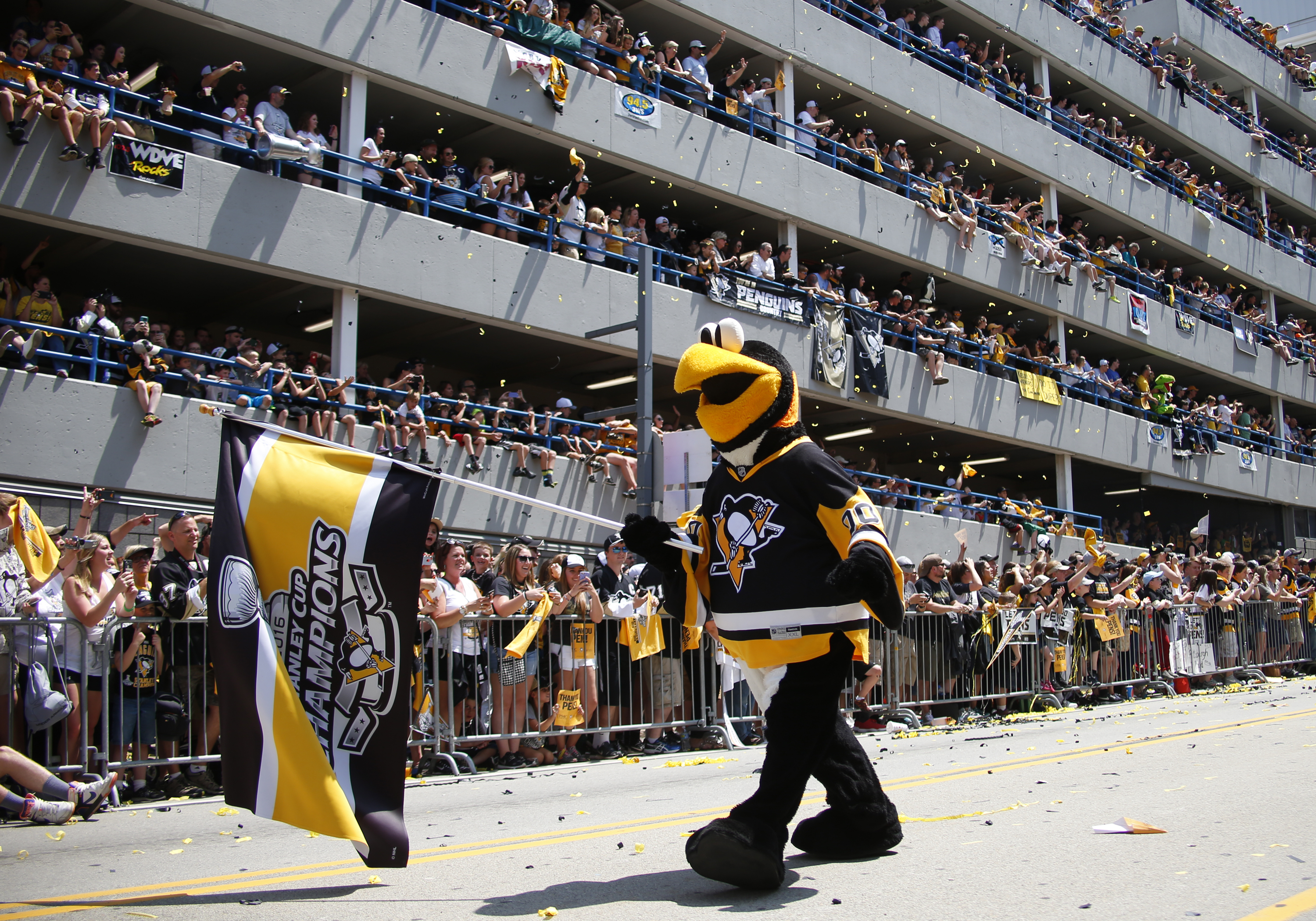 Iceburgh marches through the streets of downtown Pittsburgh in the 2016 Stanley Cup Victory Parade as a large crowd of fans cheers from the side of the road