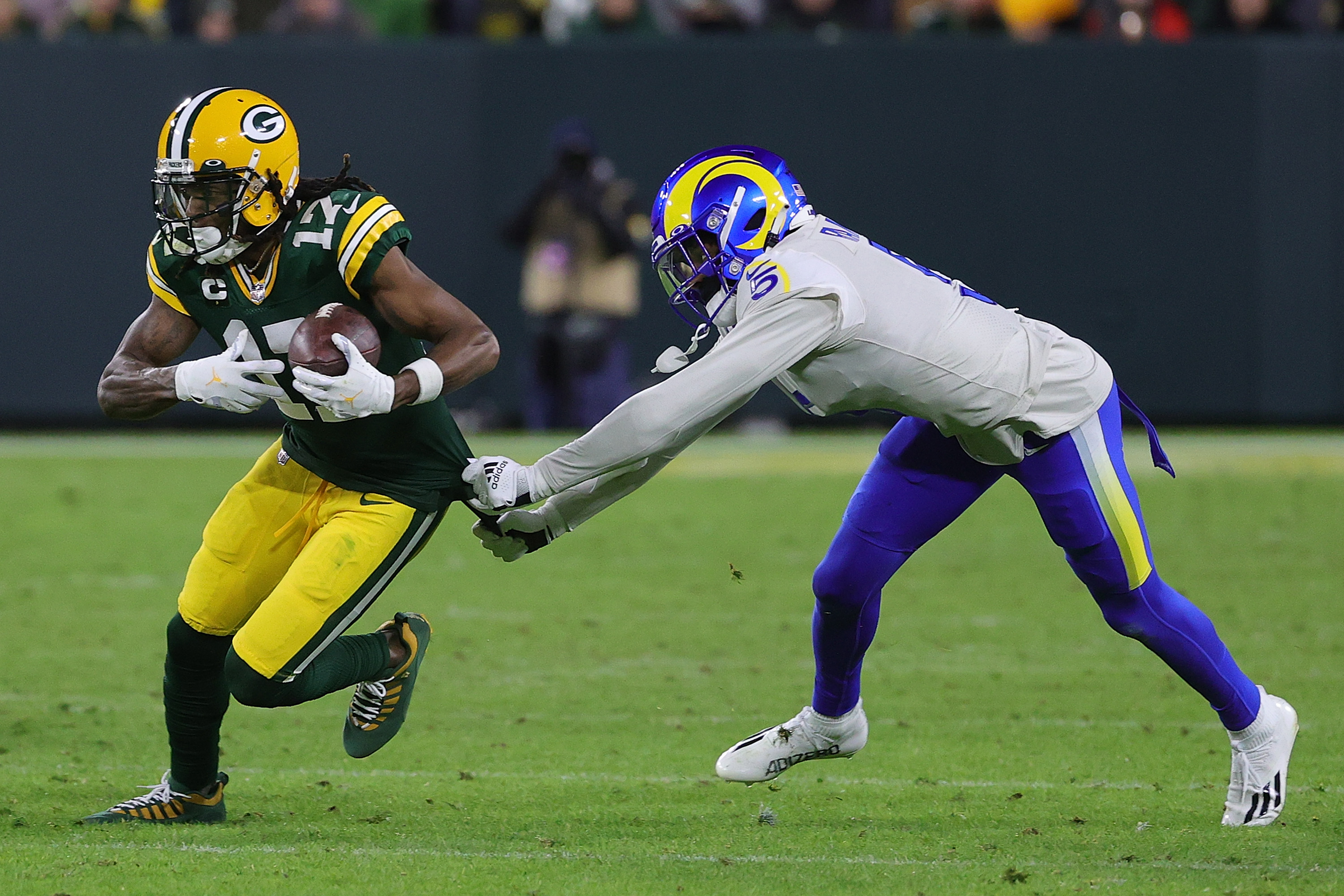 Davante Adams #17 of the Green Bay Packers avoids a tackle by Jalen Ramsey #5 of the Los Angeles Rams during a game at Lambeau Field on November 28, 2021 in Green Bay, Wisconsin.
