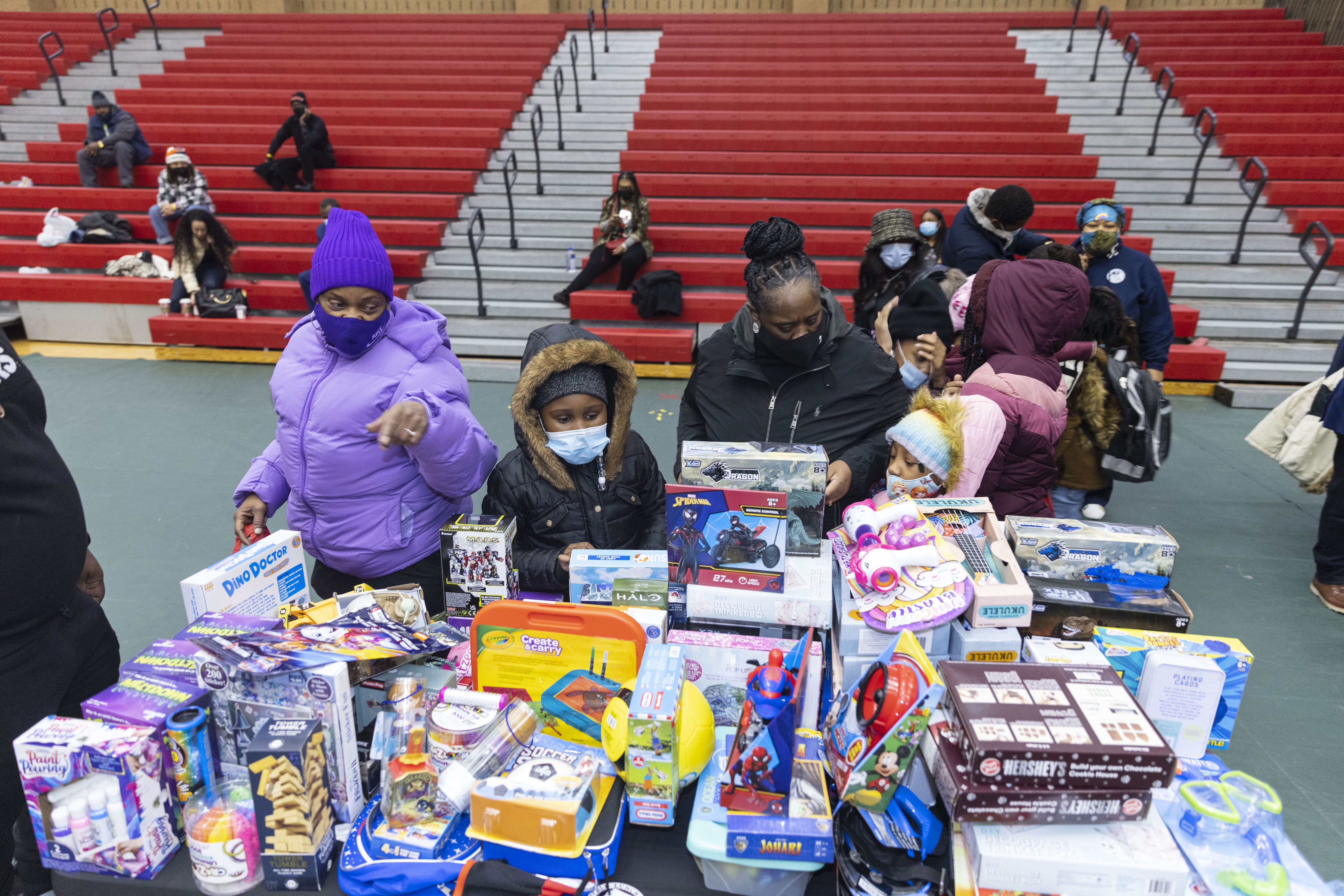 Kids try to pick out toys to take home during a Christmas gift giveaway, Sunday, Dec. 19, 2021, at Kennedy–King College in Englewood.