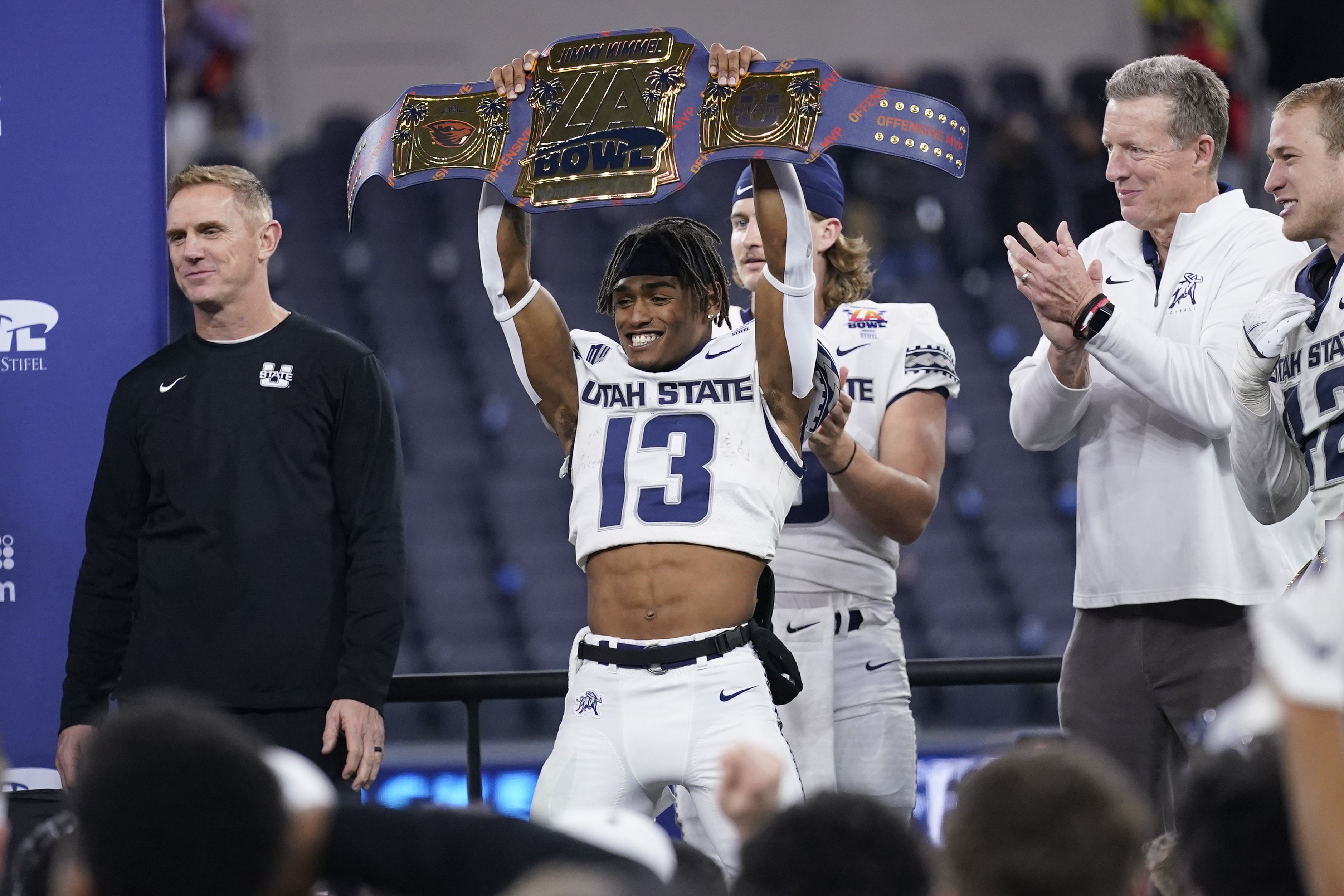 Utah State wide receiver Deven Thompkins (13) holds a championship belt after they beat Oregon State.