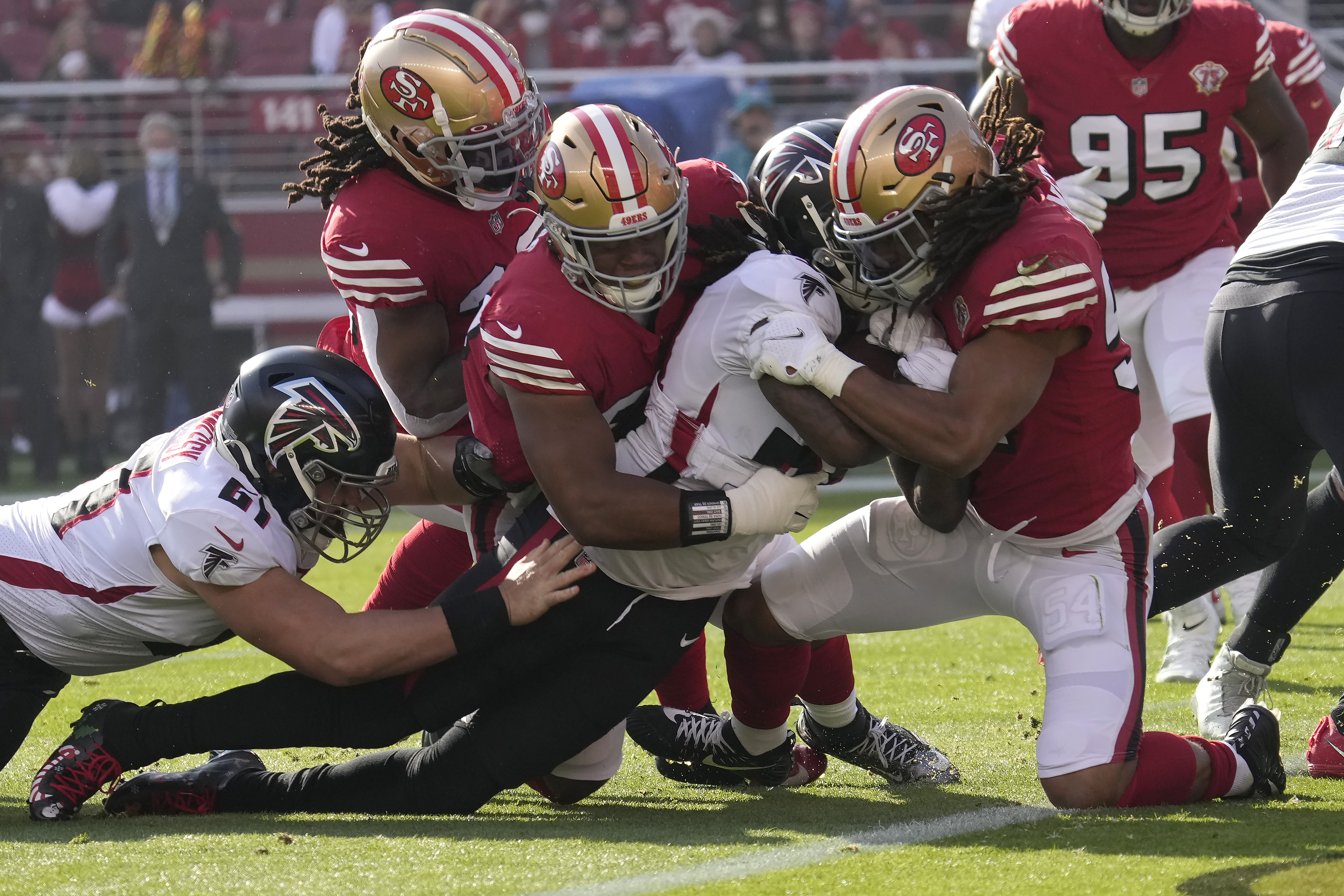 Atlanta Falcons running back Cordarrelle Patterson, middle right, is tackled at the goal line by San Francisco 49ers defensive tackle Kevin Givens, middle, and middle linebacker Fred Warner, right, during an NFL game.
