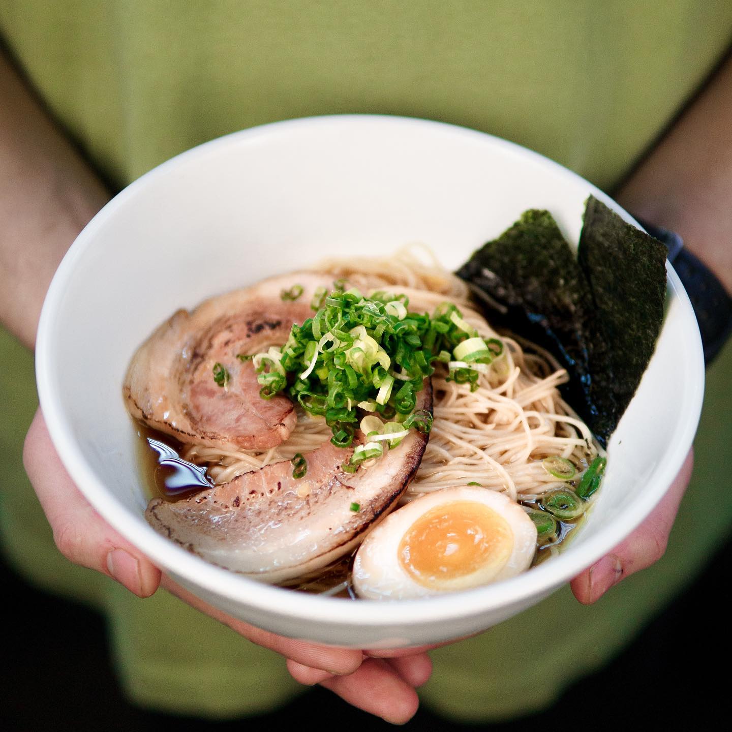person holding bowl of ramen.