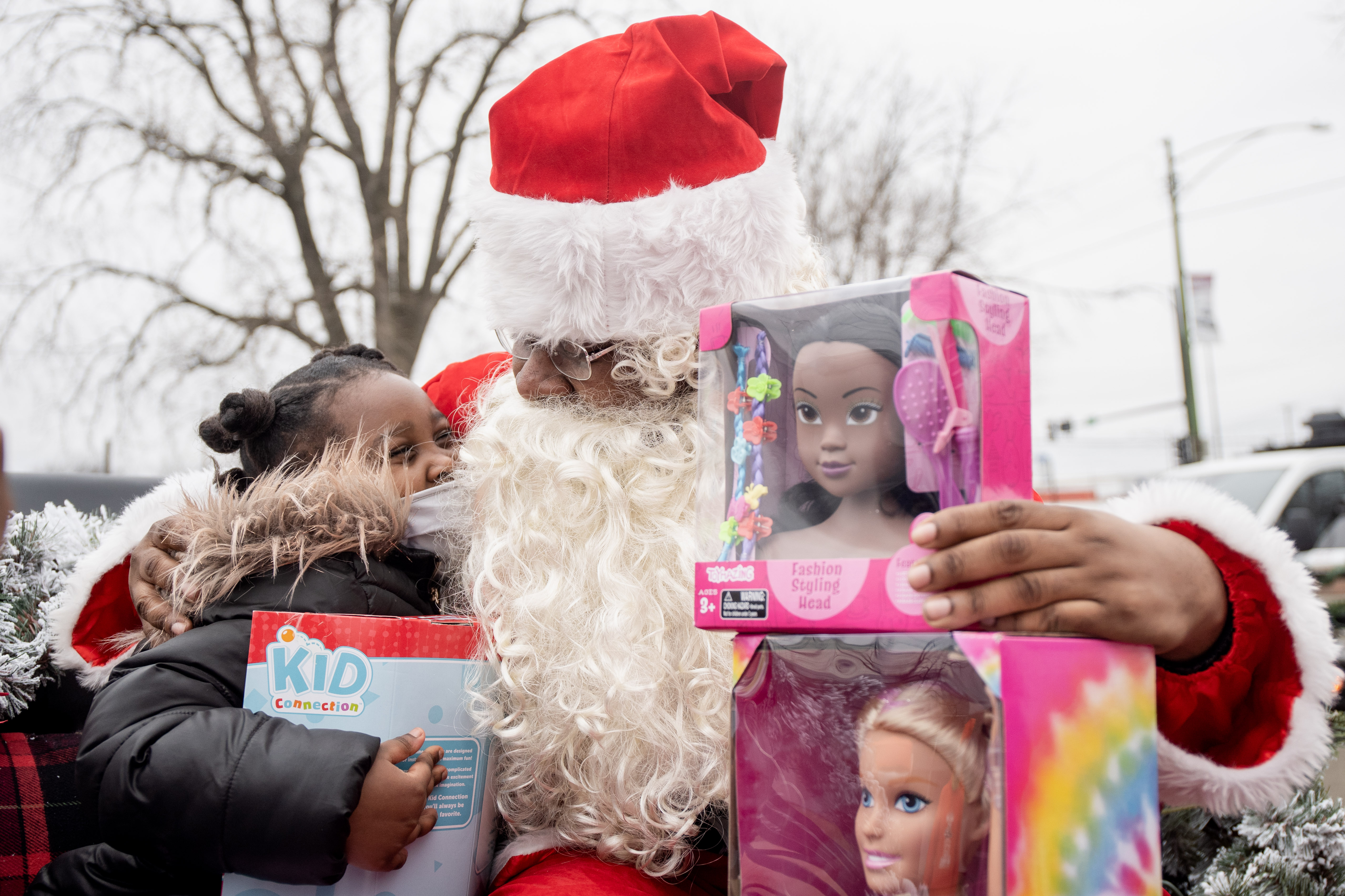 Early Walker, dressed as Santa Claus, hugs Aubrey Broughton, sister of 7-year-old Serenity Brughton, who was fatally shot in August, in the parking lot of the 5th District Police station in Pullman on Friday.