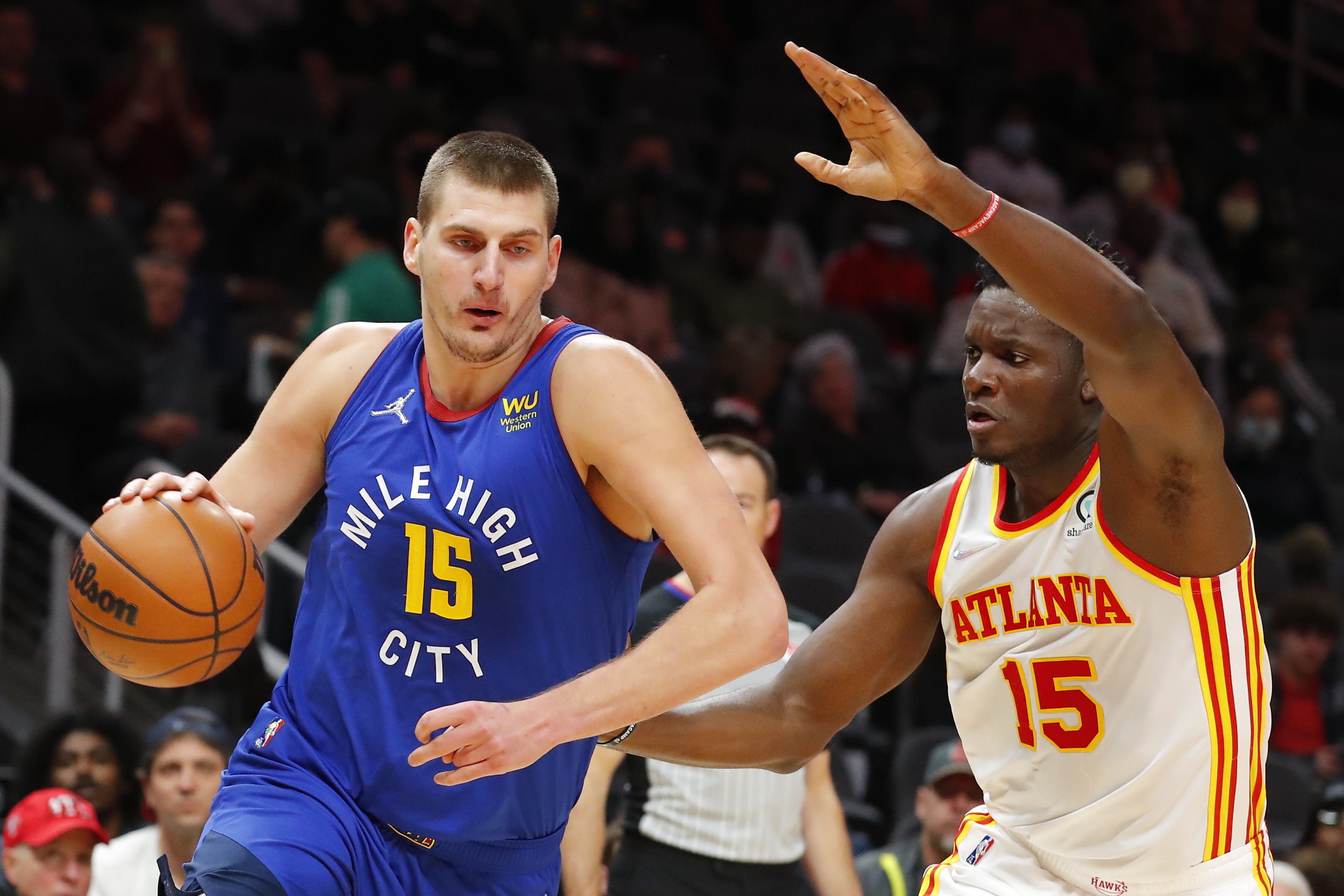 Nikola Jokic #15 of the Denver Nuggets drives tot he basket against Clint Capela #15 of the Atlanta Hawks during the first half at State Farm Arena on December 17, 2021 in Atlanta, Georgia.