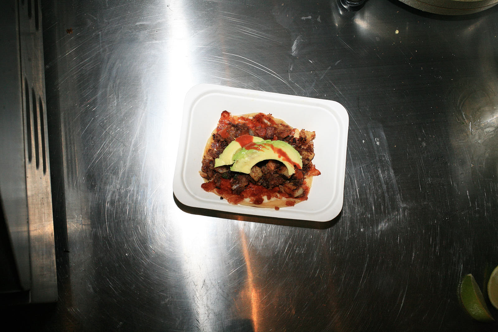 A Sonoran beef taco on the steel counter at Sonora.