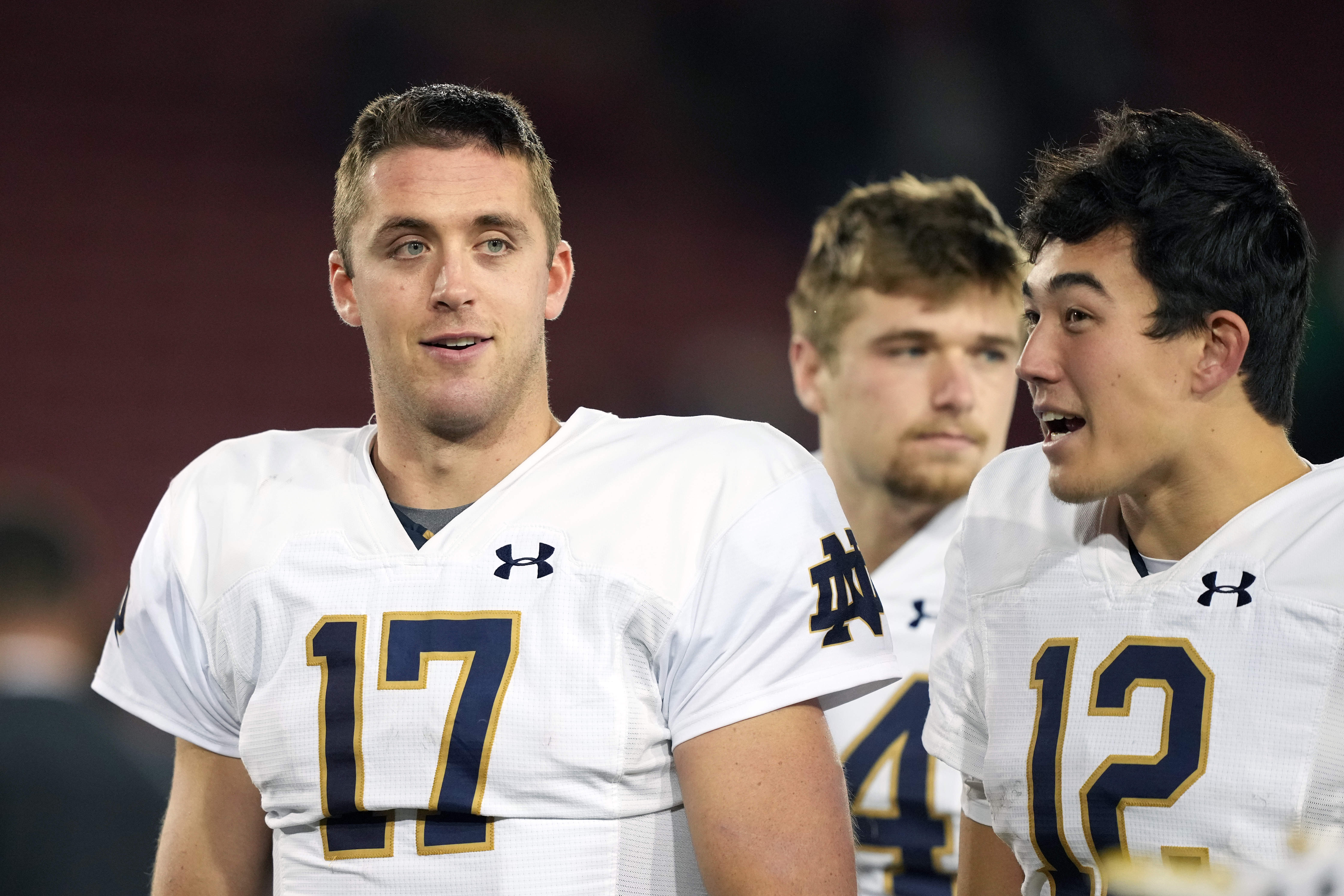 Notre Dame Fighting Irish quarterbacks Jack Coan and Tyler Buchner walk off the field after the game against the Stanford Cardinal at Stanford Stadium