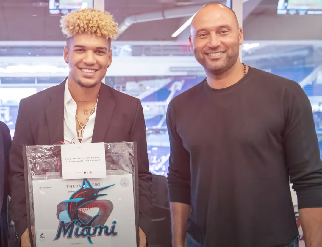 Marlins prospect Víctor Mesa Jr. accepts an award from CEO Derek Jeter at the end of the 2021 minor league season