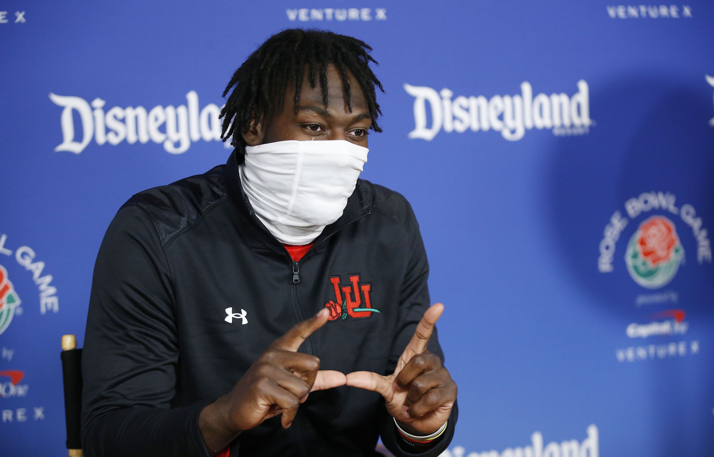 Utah Utes linebacker Devin Lloyd flashes a “U” during a press conference at Disneyland in Anaheim, Calif., on Monday, Dec. 27, 2021, as part of events leading up to the Rose Bowl.