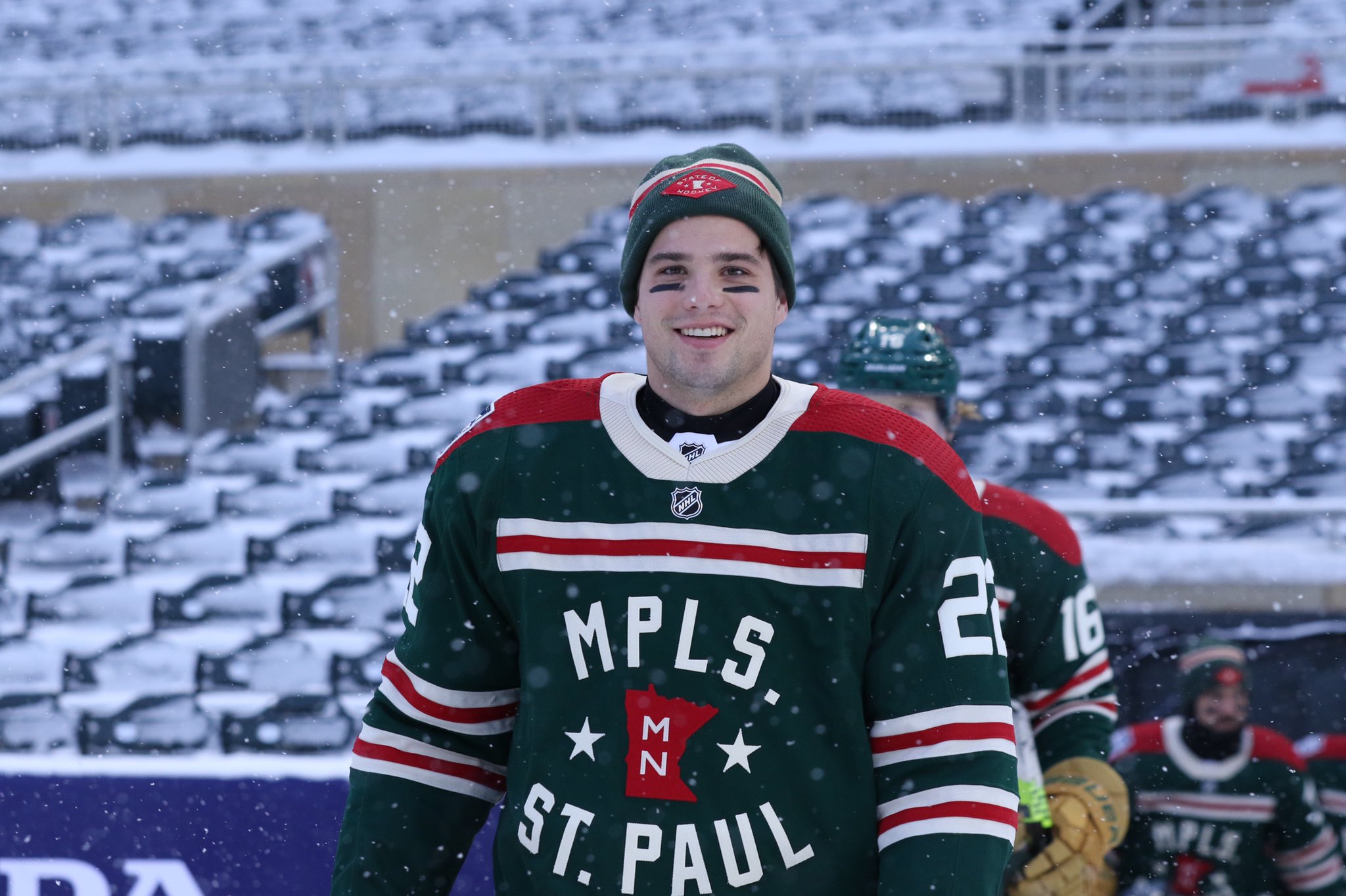 Kevin Fiala smiling while walking to the ice in Target Field, wearing the Wild’s Winter Classic uniform