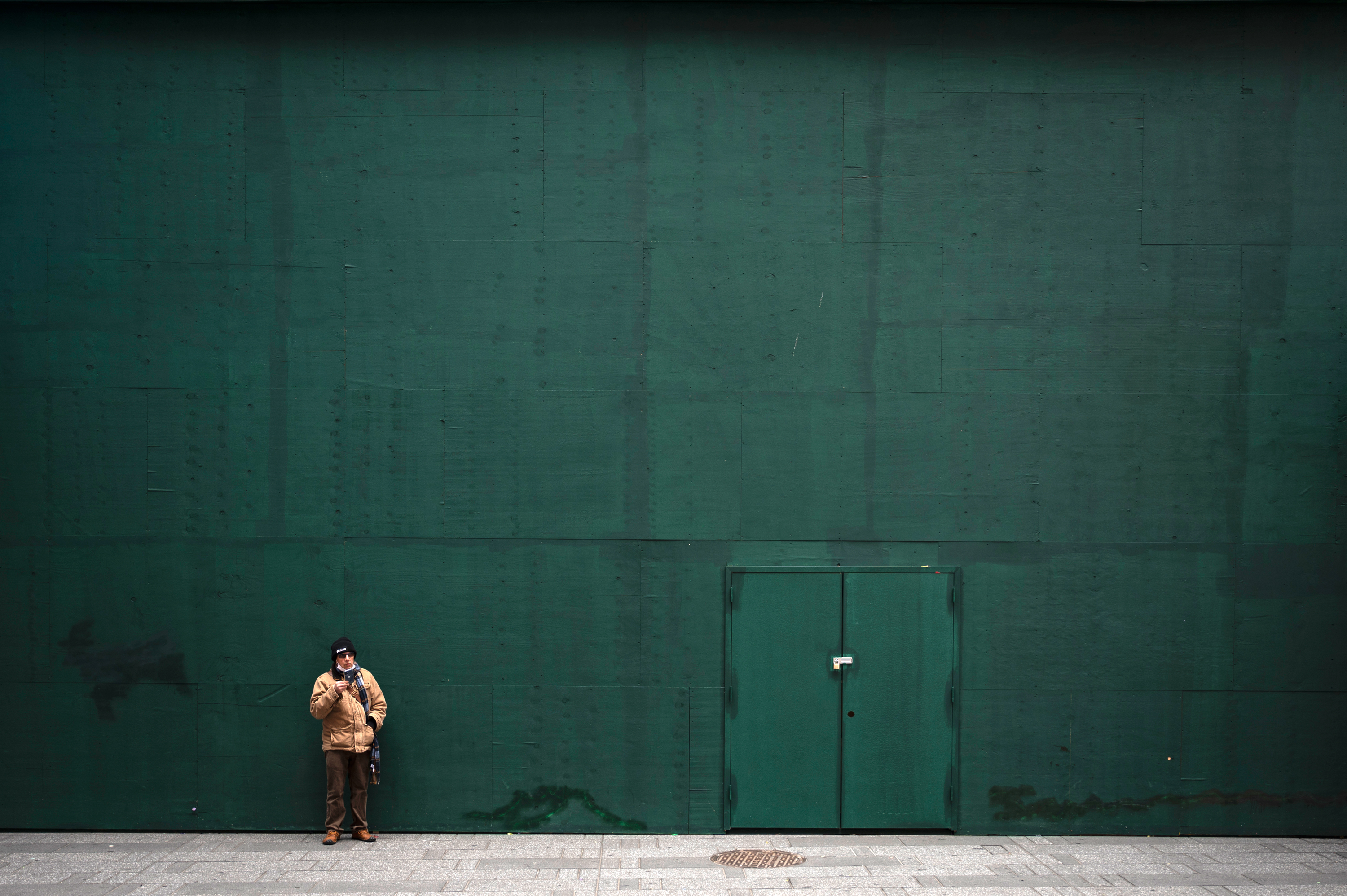 A man stands in front of a shuttered business in Times Square, Jan. 15, 2020.