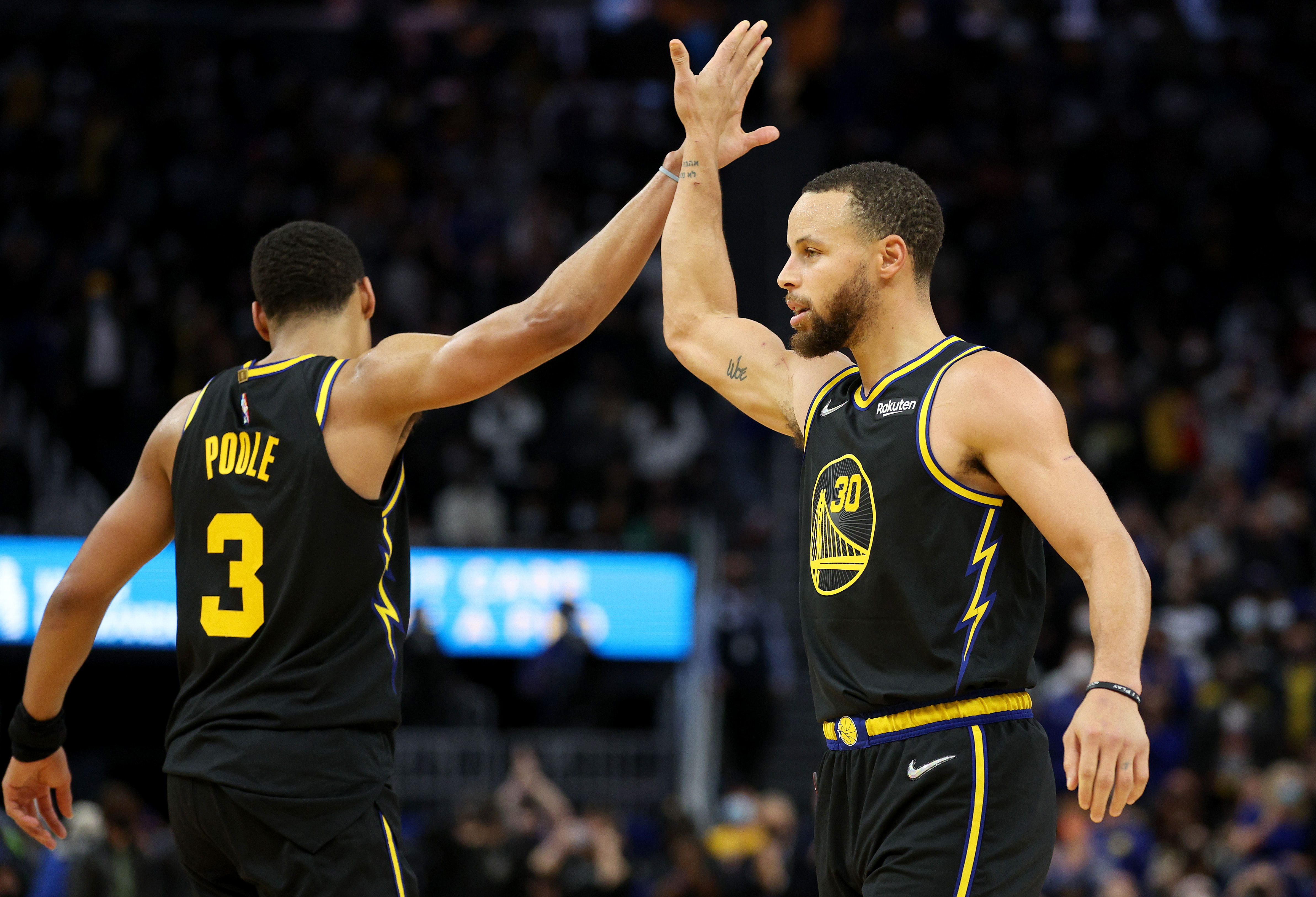 Warriors guard Stephen Curry high fives Jordan Poole during their game against the Heat.