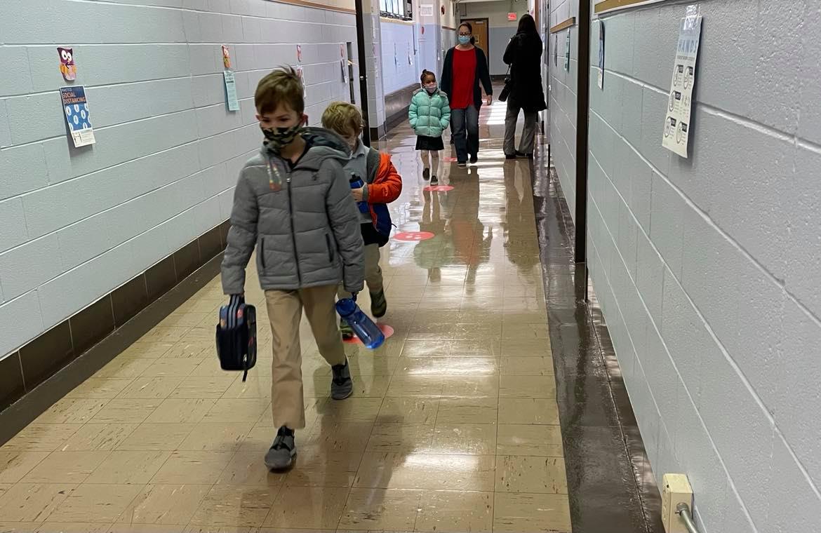 Wearing masks, kindergarten students walk back to their classroom after taking a restroom break at Chester Arthur Elementary School in South Philadelphia.