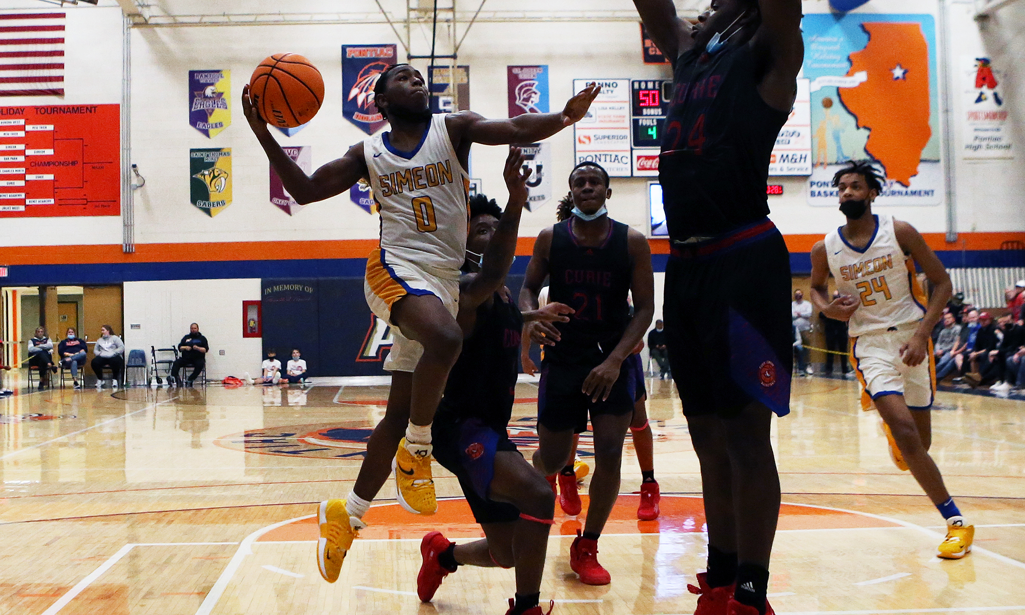 Simeon’s Aviyon Morris (0) takes the ball to the hoop against Curie.