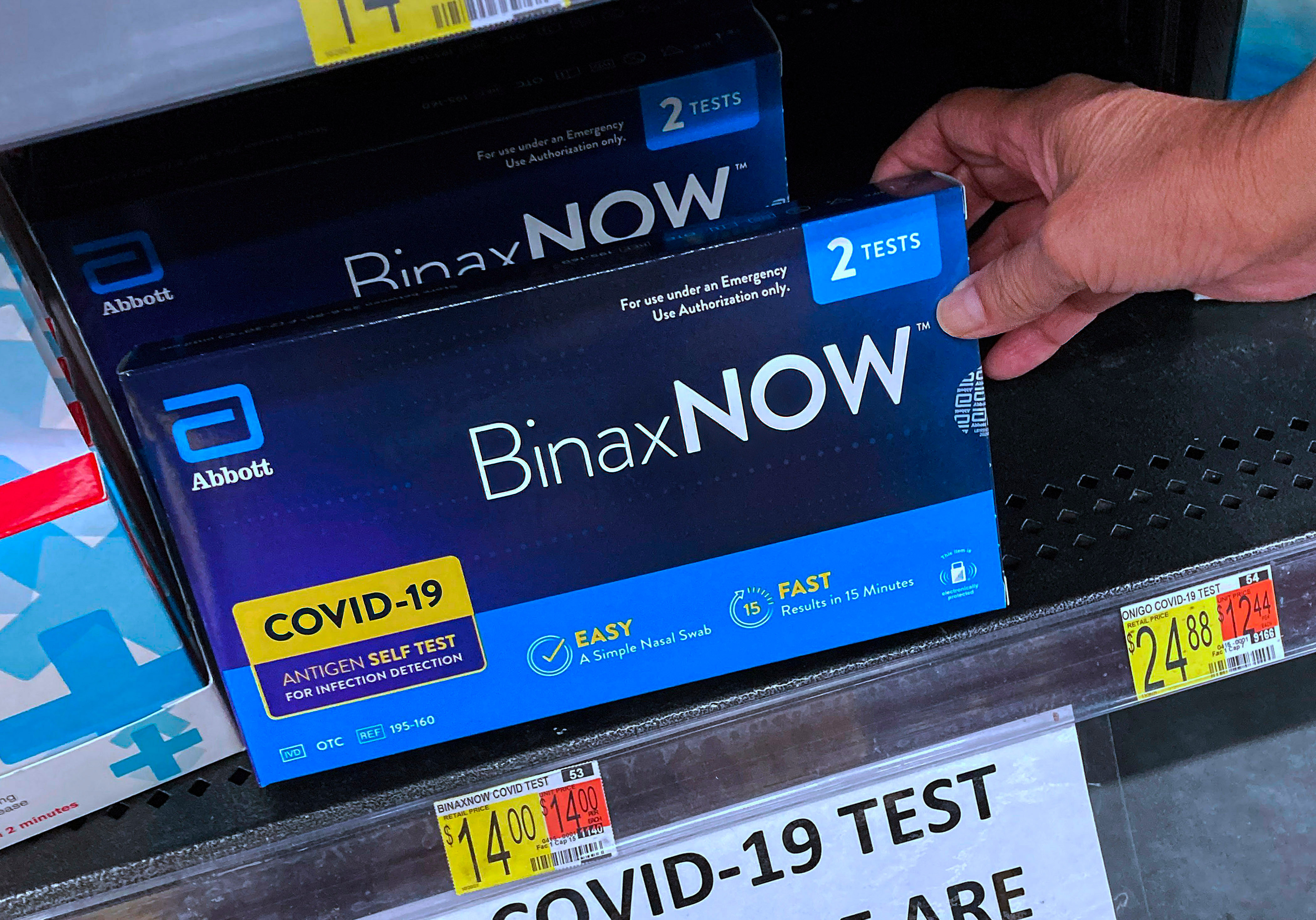 COVID-19 home rapid test kits are seen on a shelf at a...