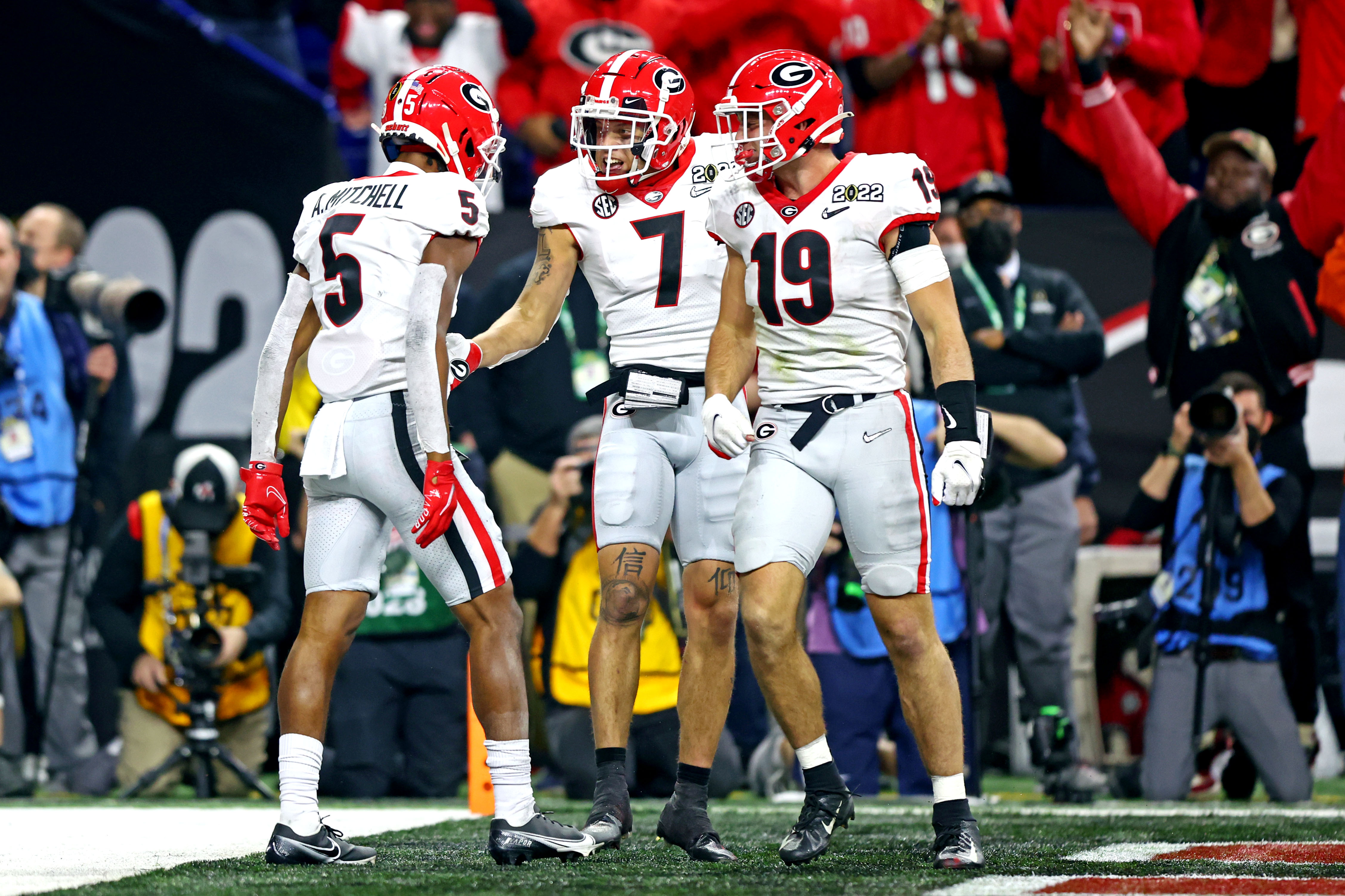 Georgia Bulldogs wide receiver Adonai Mitchell celebrates with wide receiver Jermaine Burton and tight end Brock Bowers after scoring a touchdown during the fourth quarter against the Alabama Crimson Tide in the 2022 CFP college football national championship game at Lucas Oil Stadium.