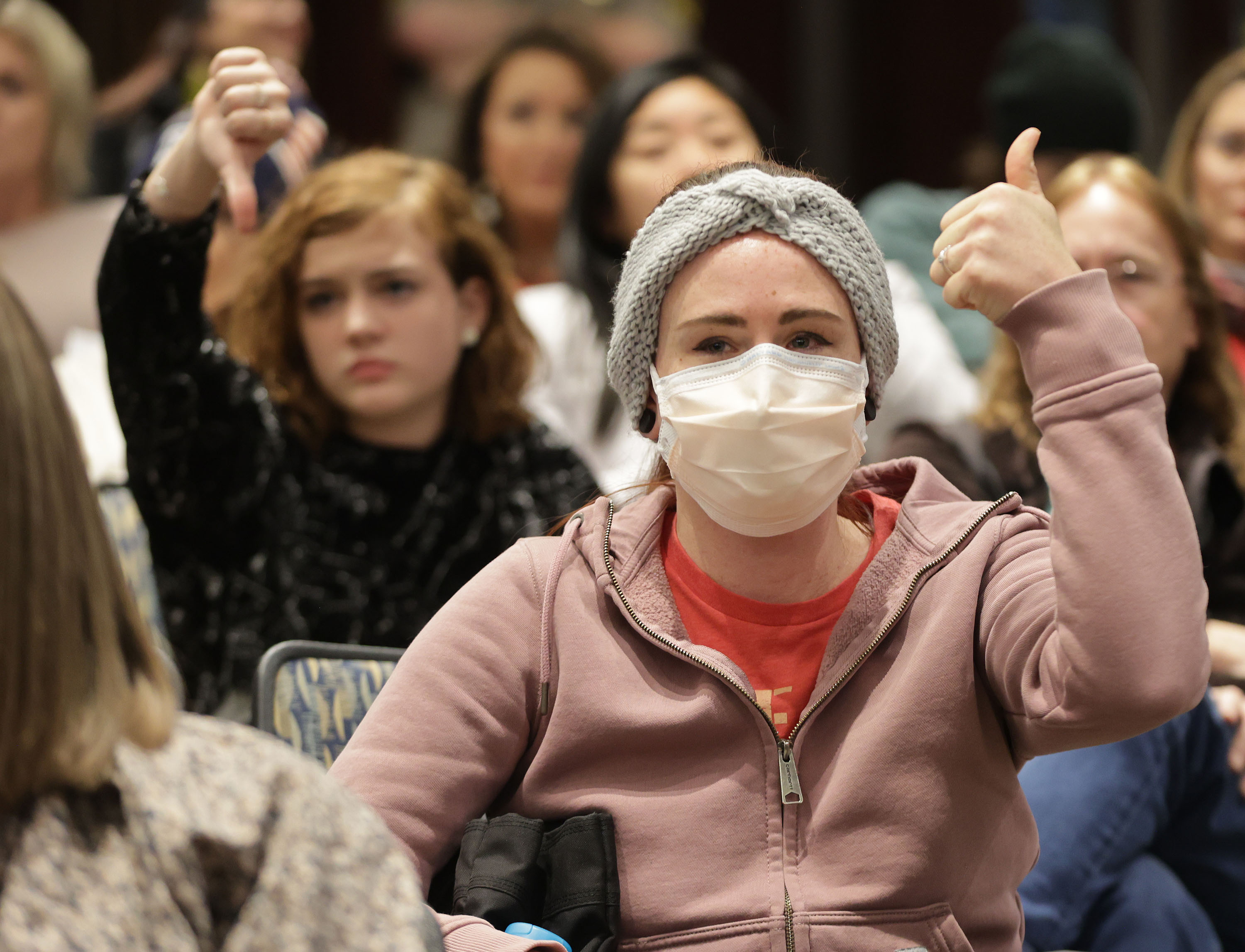 Health care worker Jeni West gives a thumbs-up as the Salt Lake County Council voted in Salt Lake City on Thursday, Jan. 13, 2022. The council left a 30-day county mask order in place.