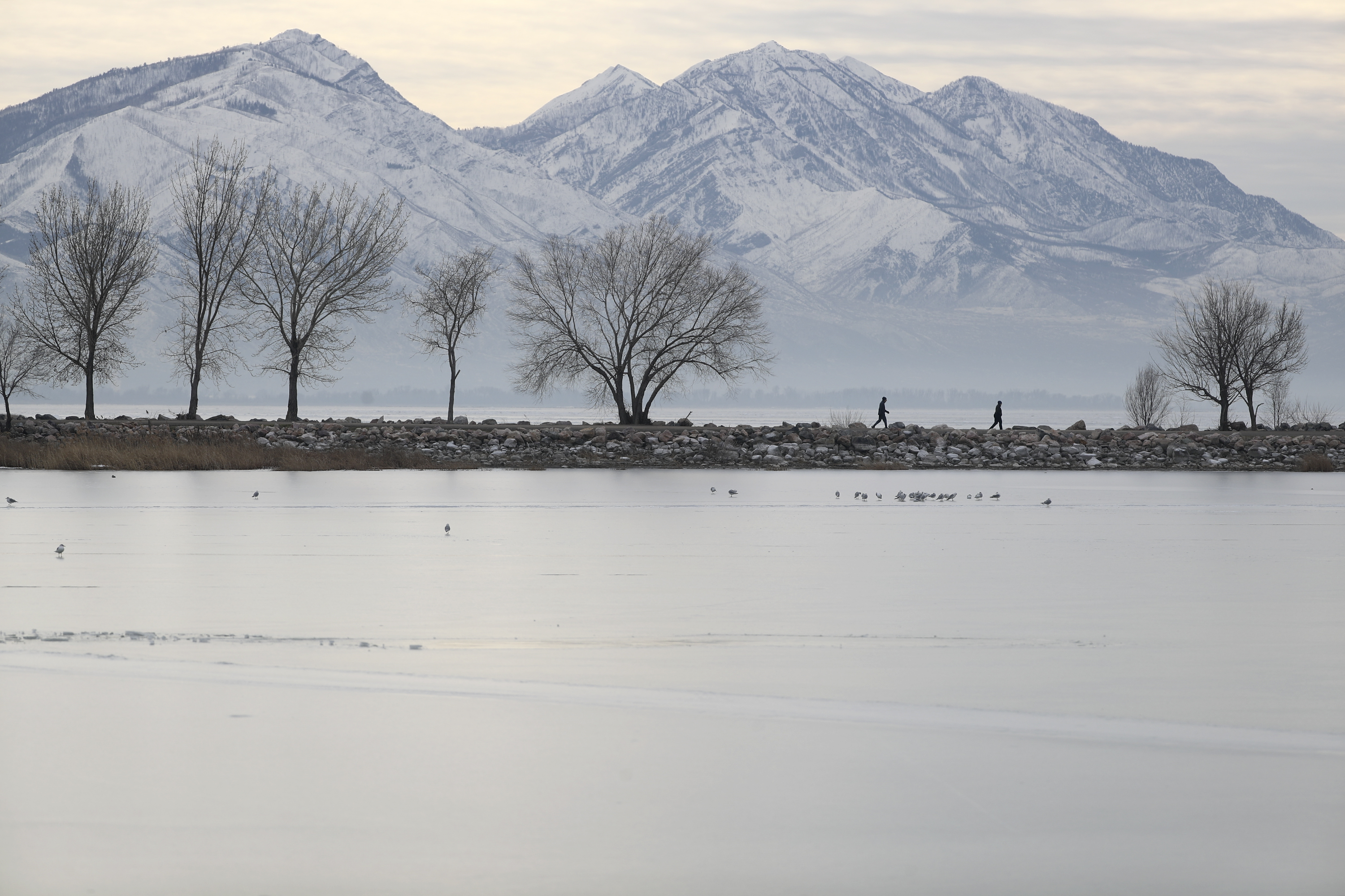 People walk on a jetty in Utah Lake State Park in Provo on Thursday, Jan. 13, 2022.&nbsp;Stakeholders gathered at Utah Valley University this week to discuss the future of the lake, including scientists, lawmakers, government officials and the public.