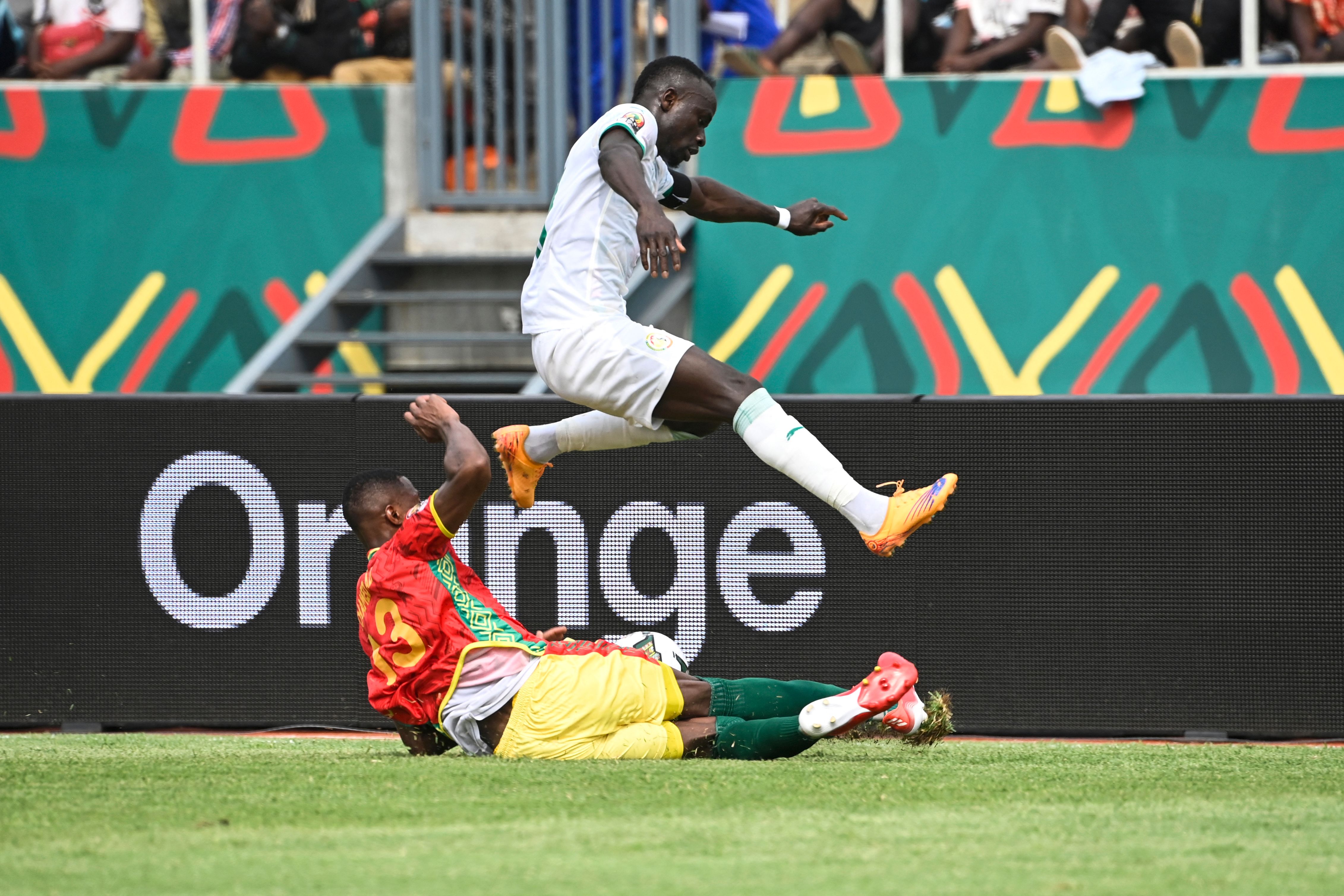 Guinea’s defender Issiaga Sylla (down) tackles Senegal’s forward Sadio Mane during the Group B Africa Cup of Nations (CAN) 2021 football match between Senegal and Guinea at Stade de Kouekong in Bafoussam on January 14, 2022. (Photo by Pius Utomi EKPEI / AFP)