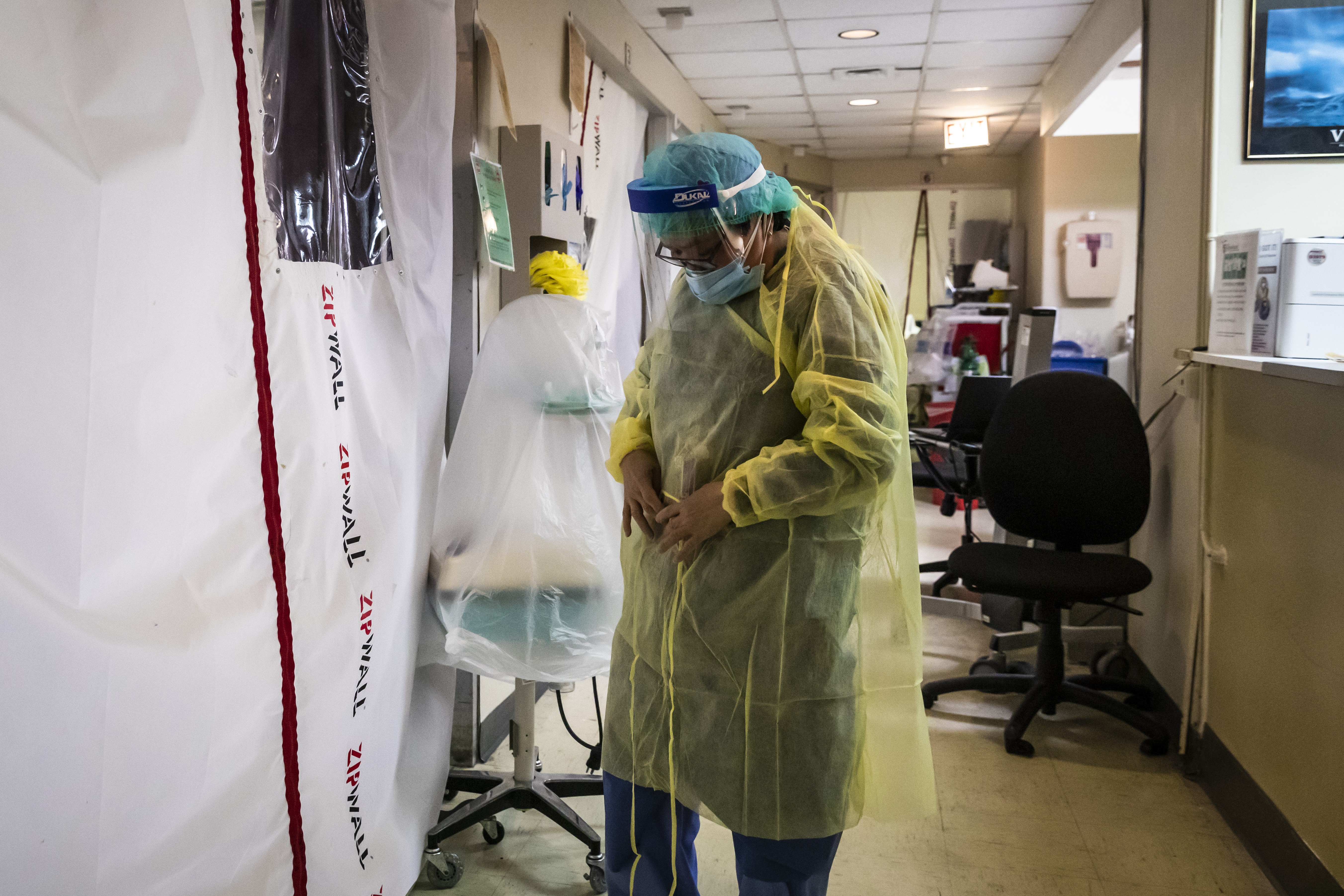 Nurse Alma Abad puts on new personal protective equipment as she prepares to check on a patient, a 59-year-old woman with COVID-19, in the Intensive Care Unit at Roseland Community Hospital earlier this month.