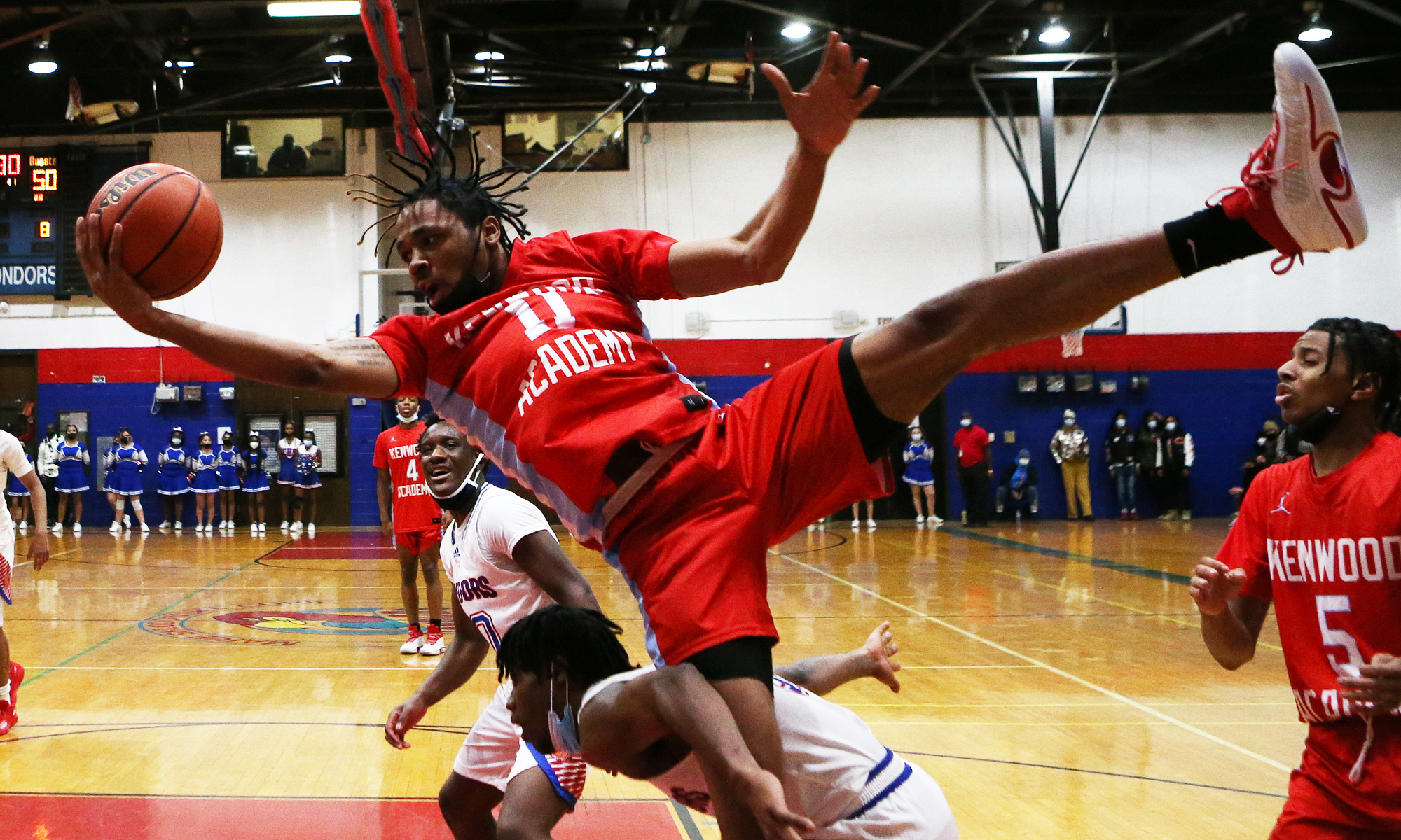 Kenwood’s Rashard Anderson (11) grabs a rebound and comes down hard as the Broncos play Curie.