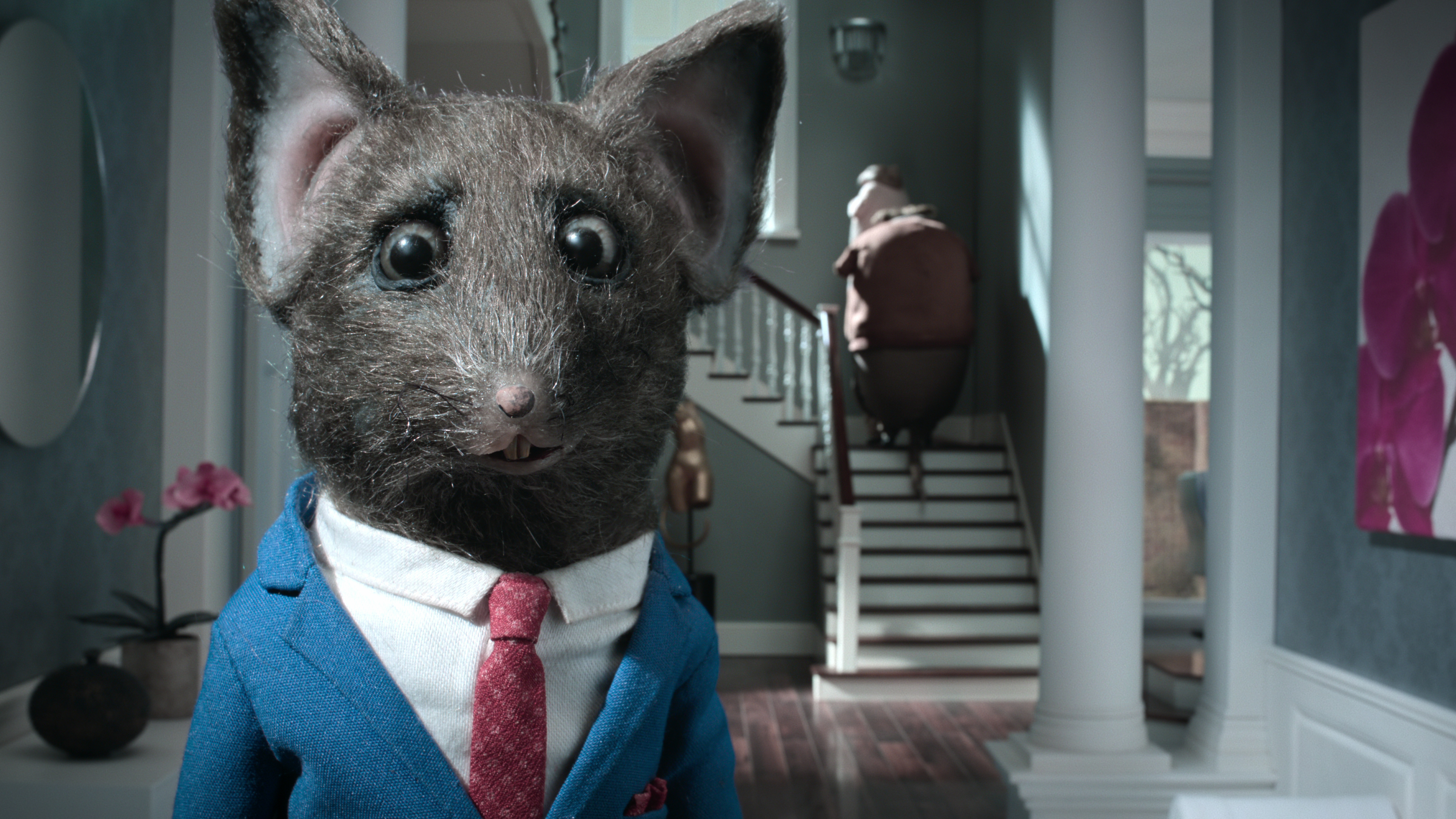 An unsettled-looking rat in a blue suit welcomes a rat couple on a tour of the house he’s trying to sell in Netflix’s stop-motion fantasy The House.