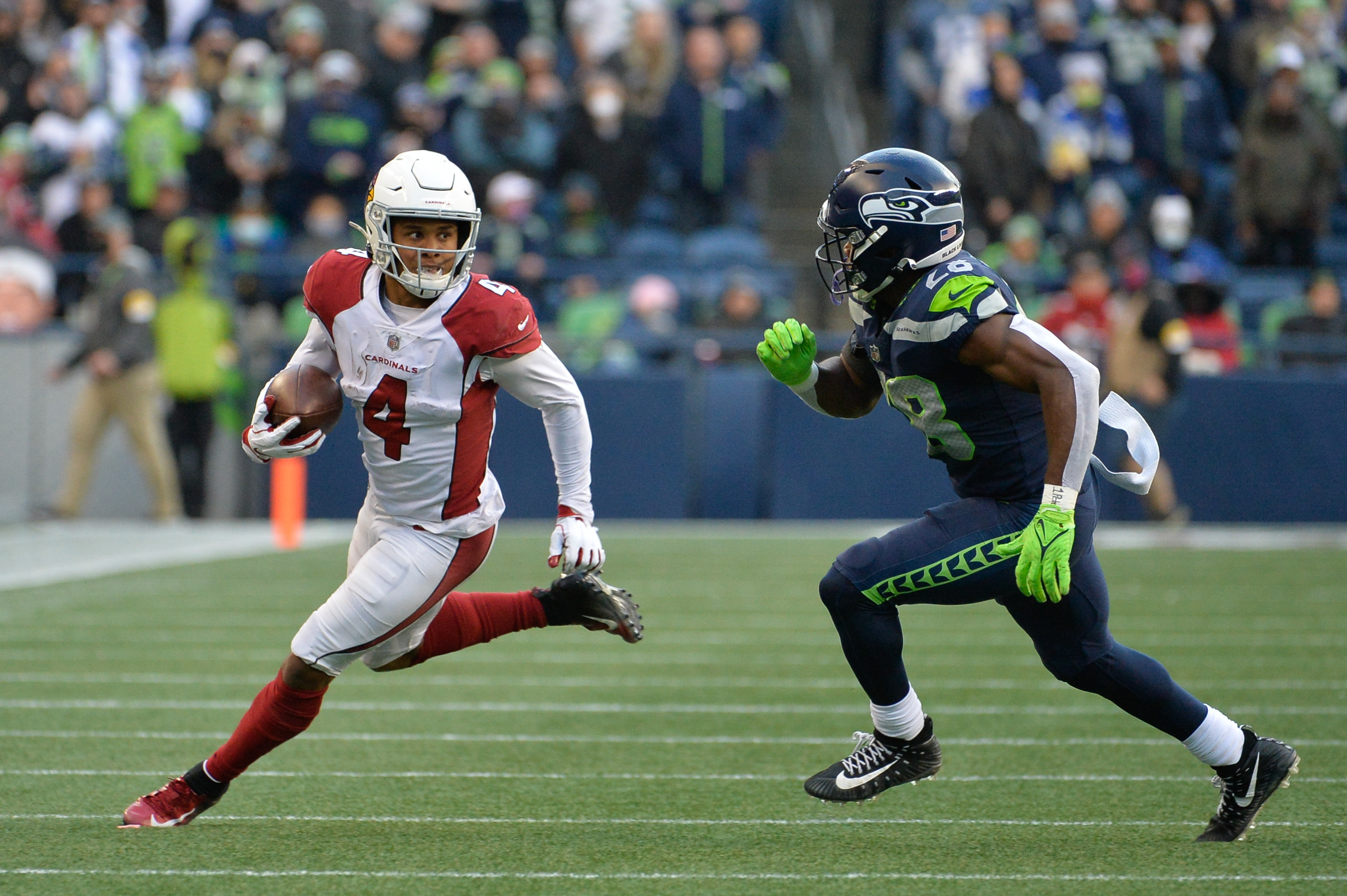 Arizona Cardinals wide receiver Rondale Moore (4) carries the ball while being chased by Seattle Seahawks cornerback Ugo Amadi (28) during the second half at Lumen Field. Arizona defeated Seattle 23-13.