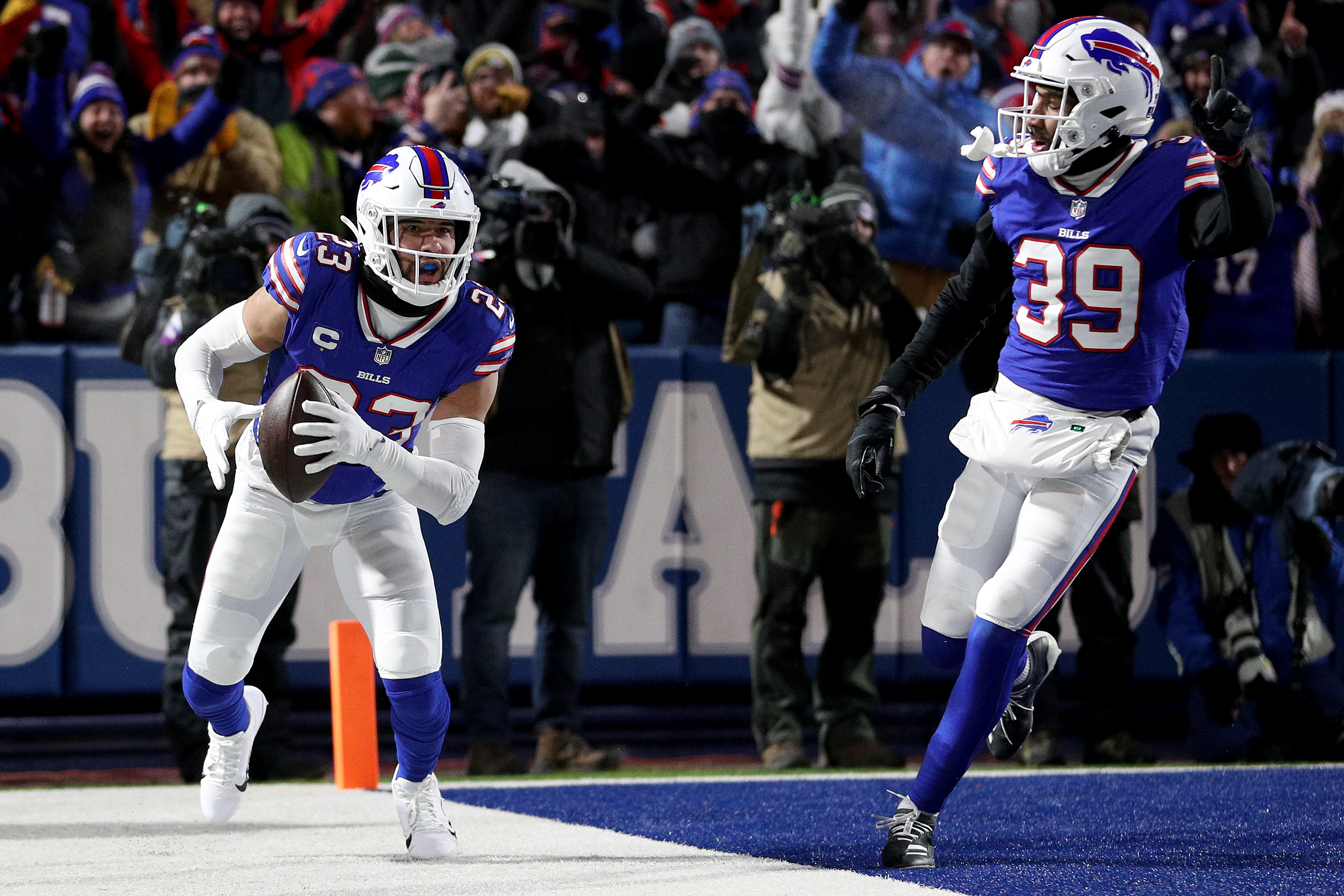 Micah Hyde #23 and Levi Wallace #39 of the Buffalo Bills react after Hyde intercepted a pass during the first quarter against the New England Patriots at Highmark Stadium on January 15, 2022 in Buffalo, New York.