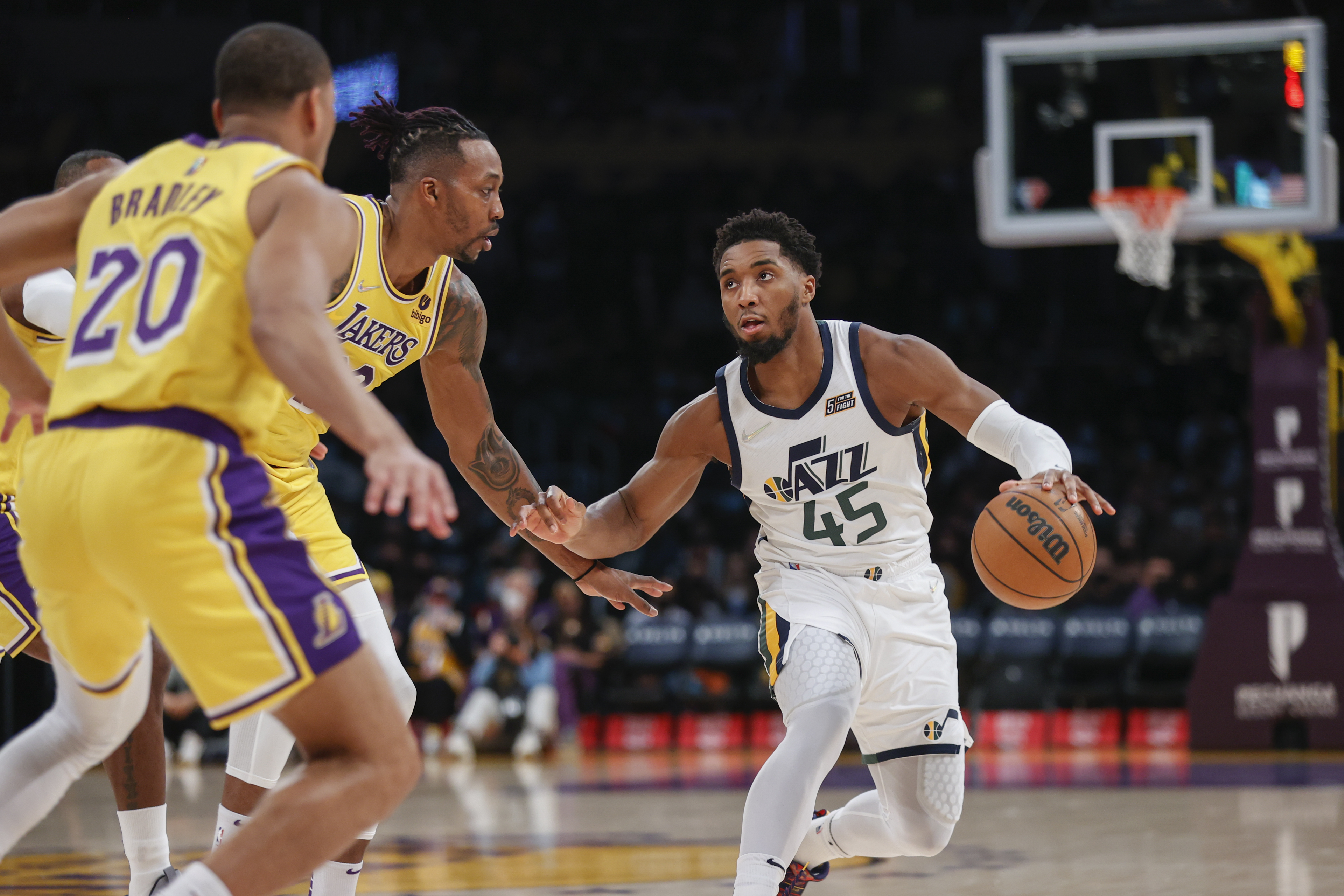 Utah Jazz guard Donovan Mitchell drives against Los Angeles Lakers center Dwight Howard and guard Avery Bradley.