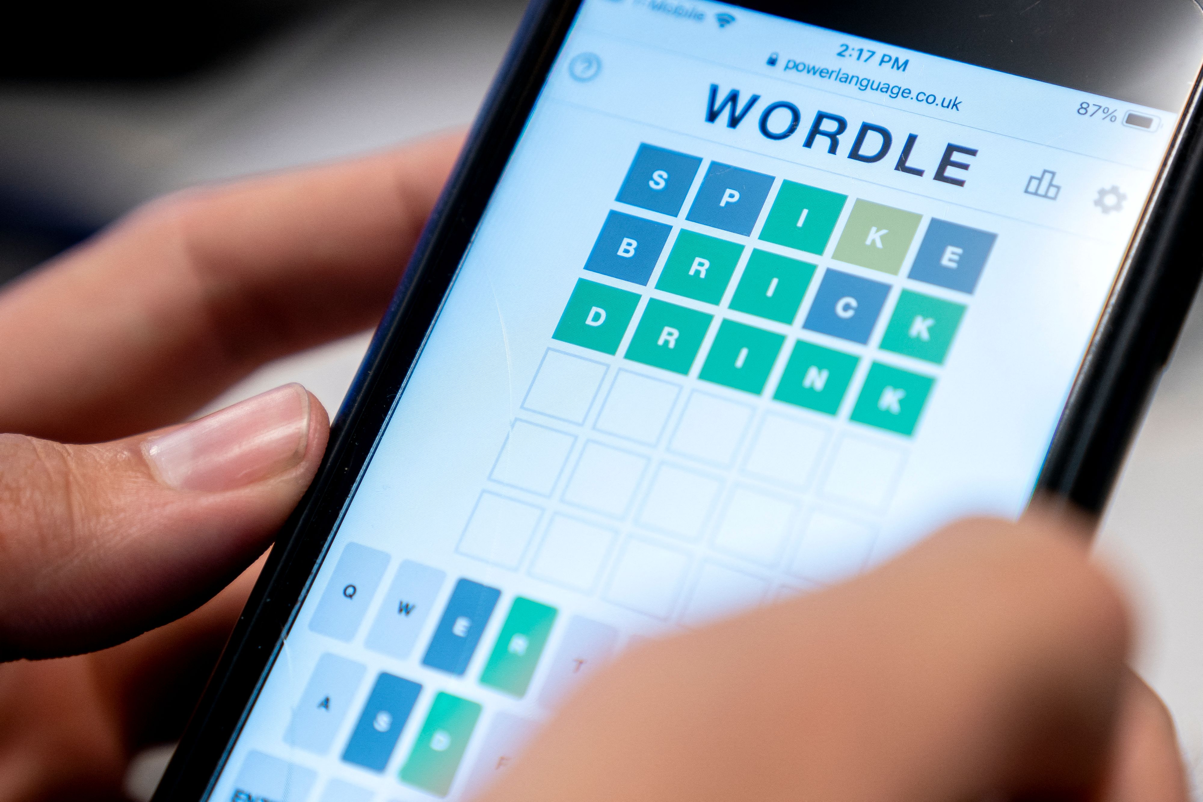 A person playing the online word game Wordle on a mobile phone.