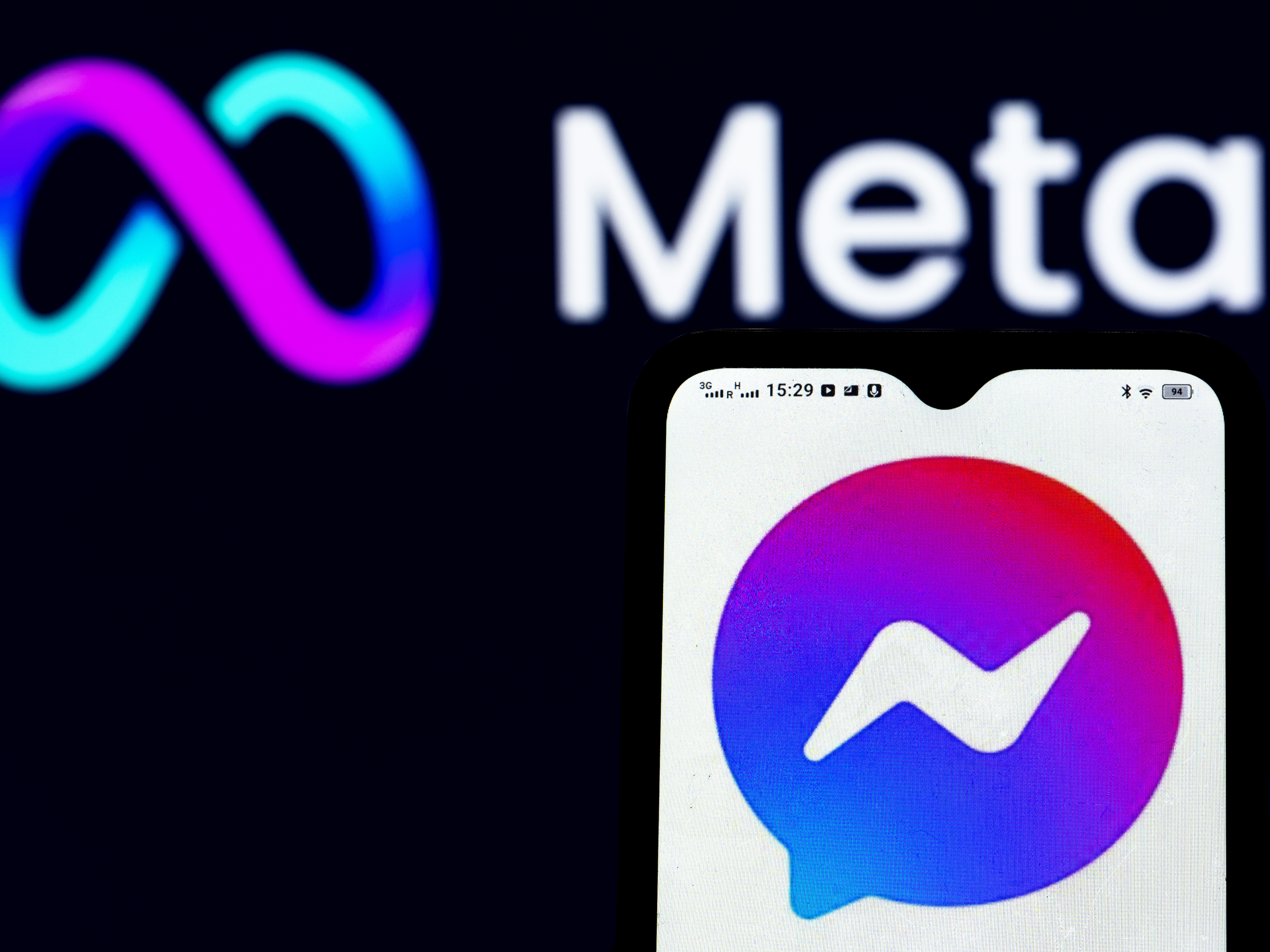 In this photo illustration a Facebook Messenger logo seen displayed on a smartphone and Meta Platforms logo in the background