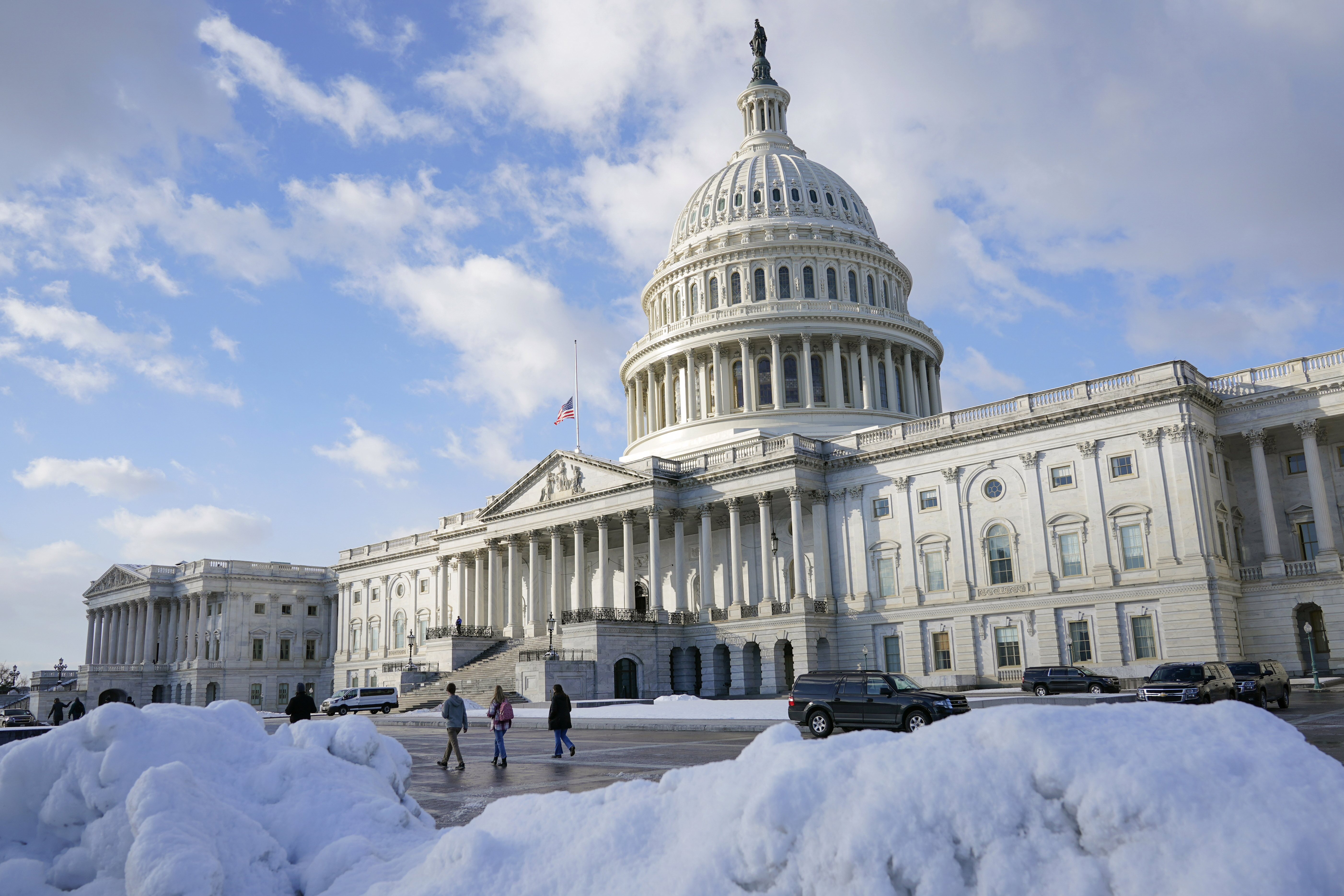 People walk outside the U.S. Capitol building in Washington, Friday, Jan. 7, 2022.