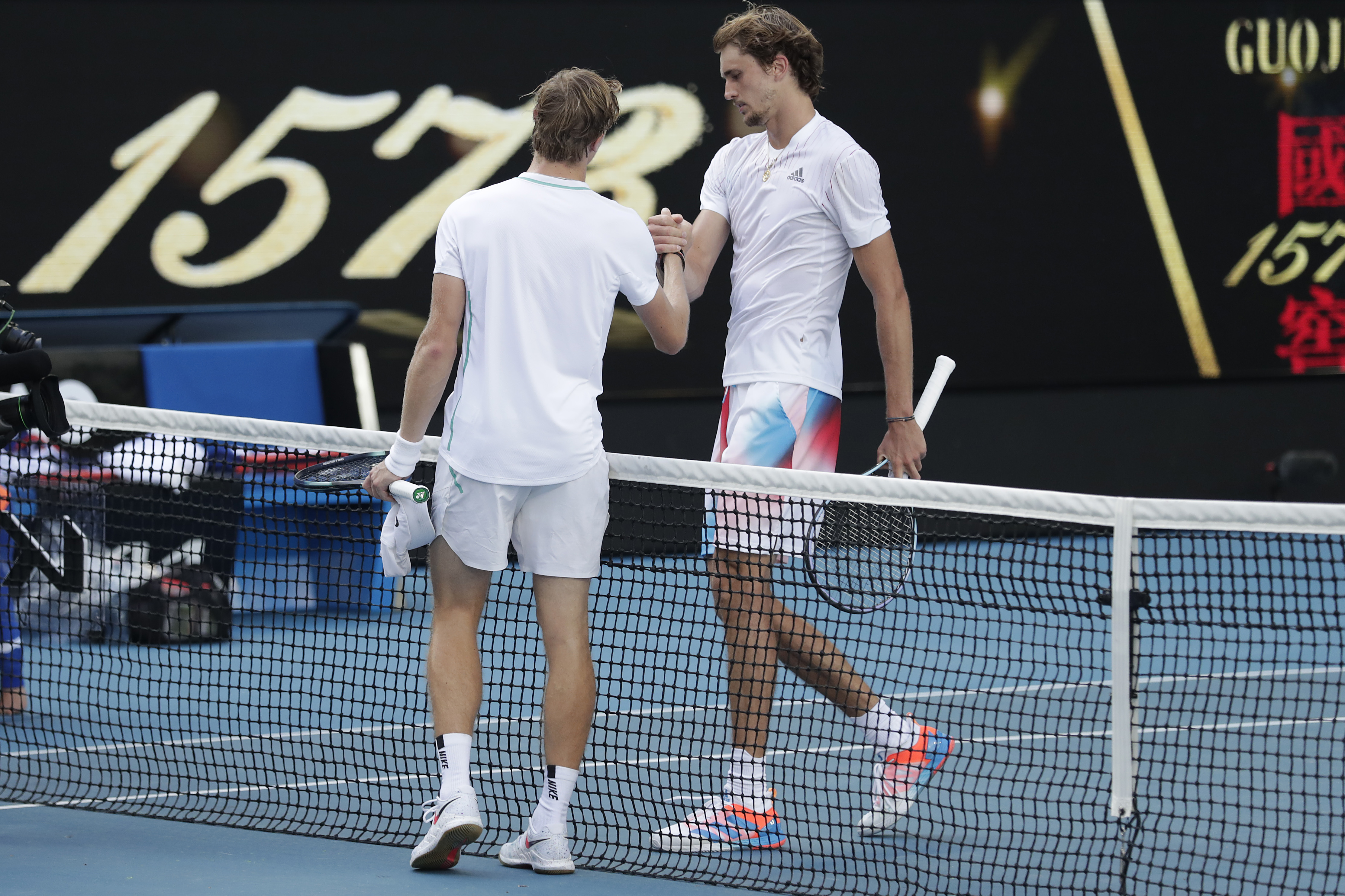 Denis Shapovalov of Canada shakes hands with Alexander Zverev (R) of Germany after winning in his fourth round singles match during day seven of the 2022 Australian Open at Melbourne Park on January 23, 2022 in Melbourne, Australia.