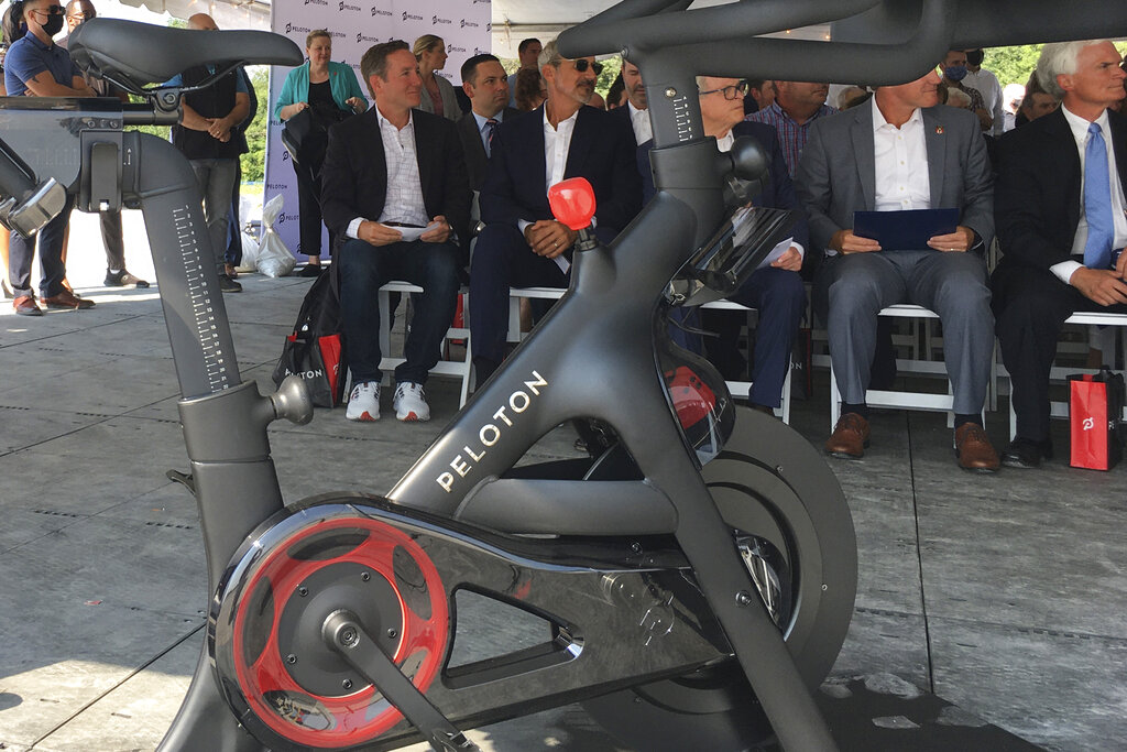 John Foley, left, is seen behind one of his company’s fitness machine along with others gathered for the groundbreaking for the company’s first U.S. factory, Monday, Aug. 9, 2021, in Luckey, Ohio.